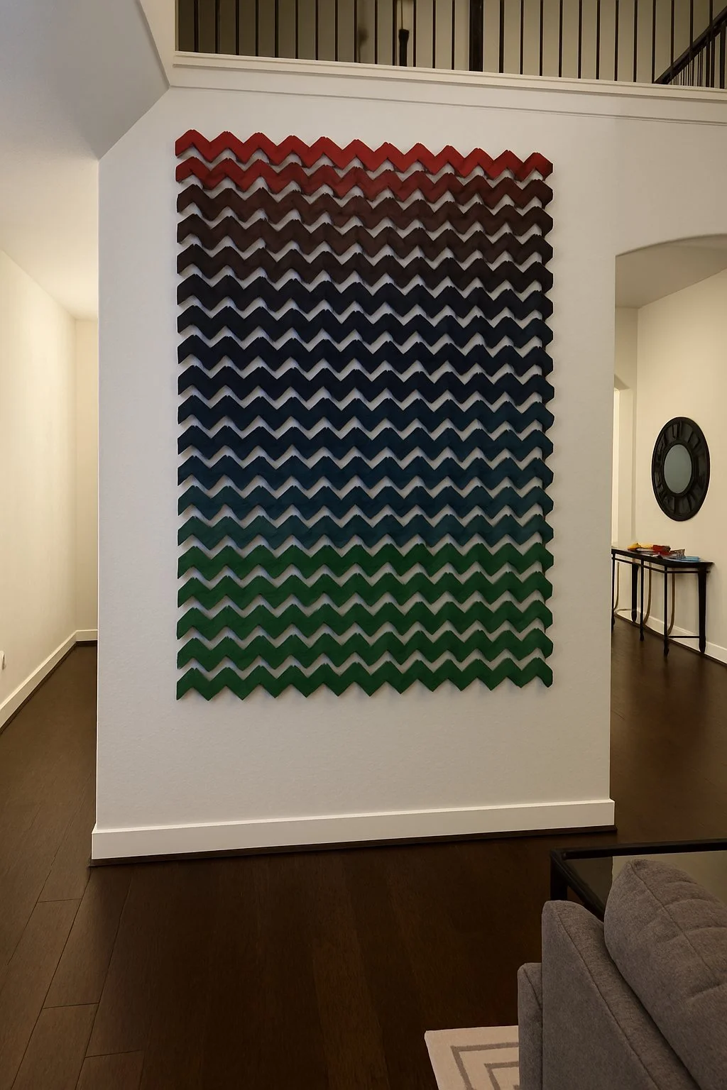 Tidal Shift, a red to blue to green chevron wood piece on a two-story wall