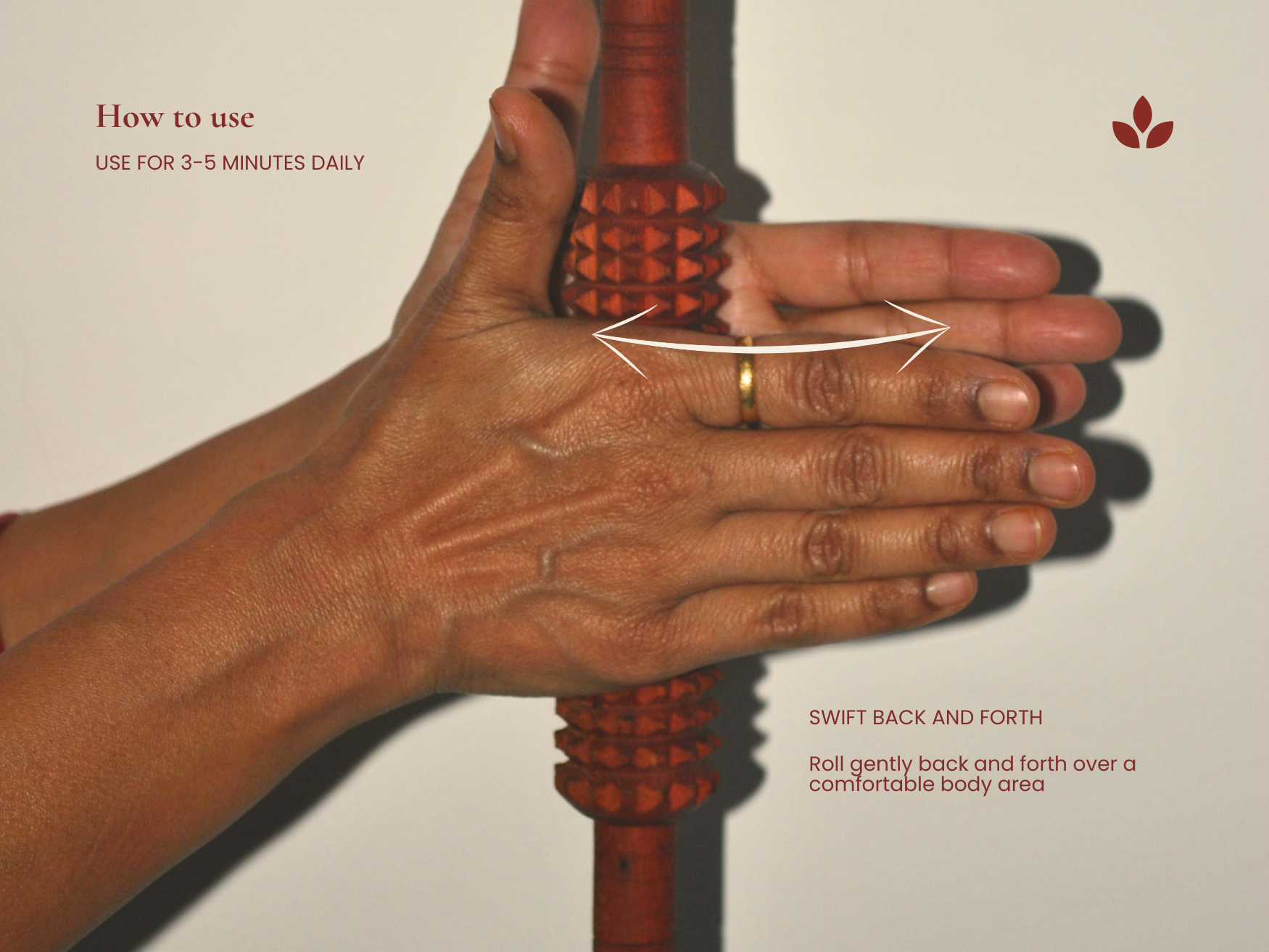 Hand demonstrating how to roll the wooden fascia release roller back and forth over a targeted muscle area.