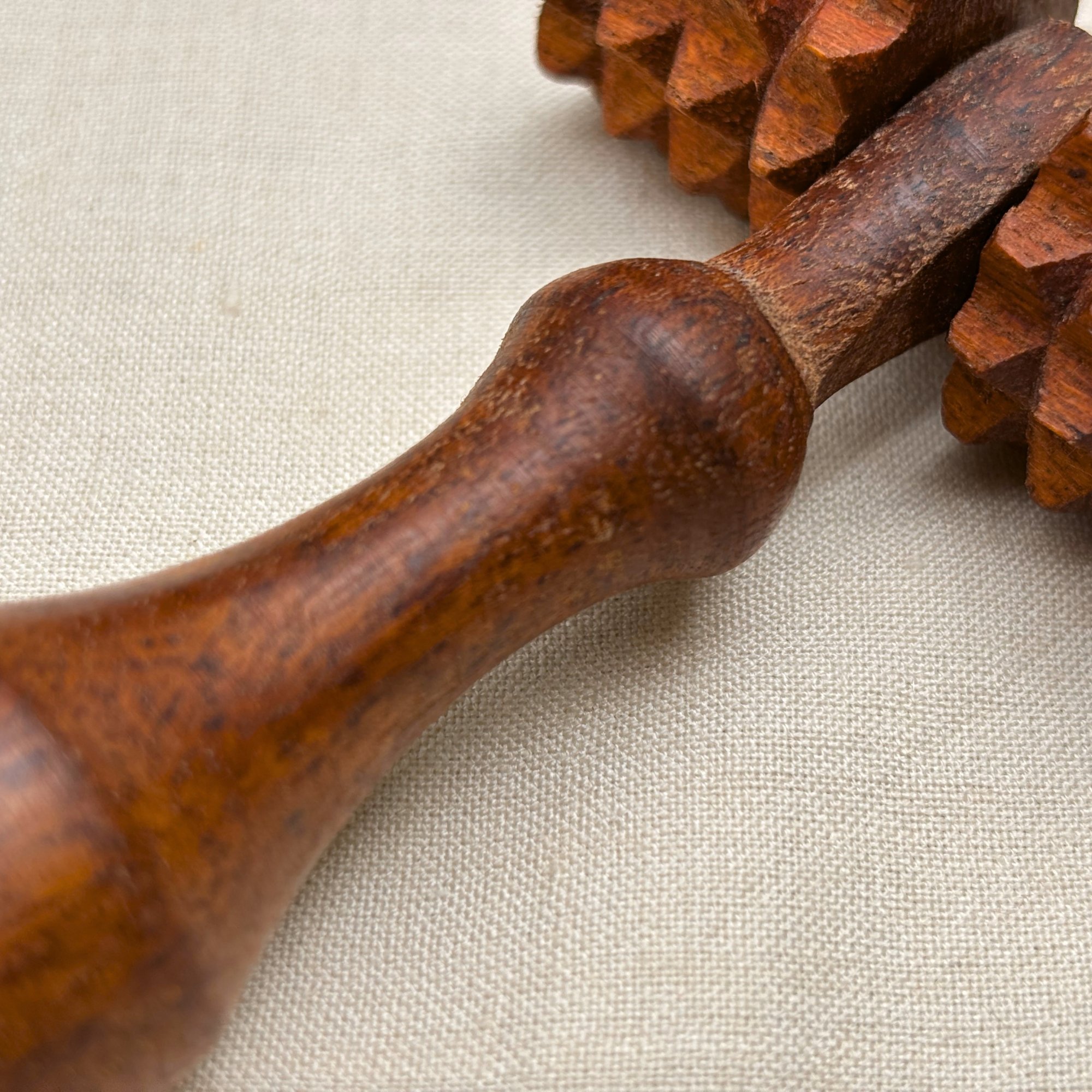 Wooden_deep_tissue_massage_roller_handle_closeup.jpg
