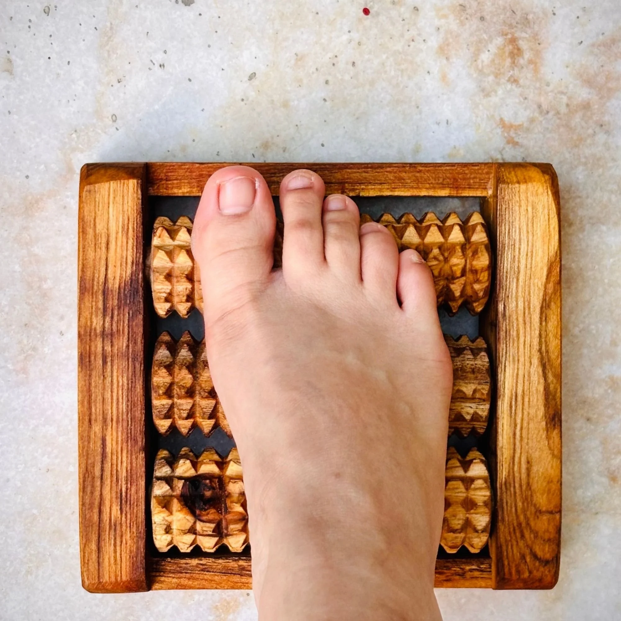 Wooden_foot_reflexology_roller_in_use.jpg