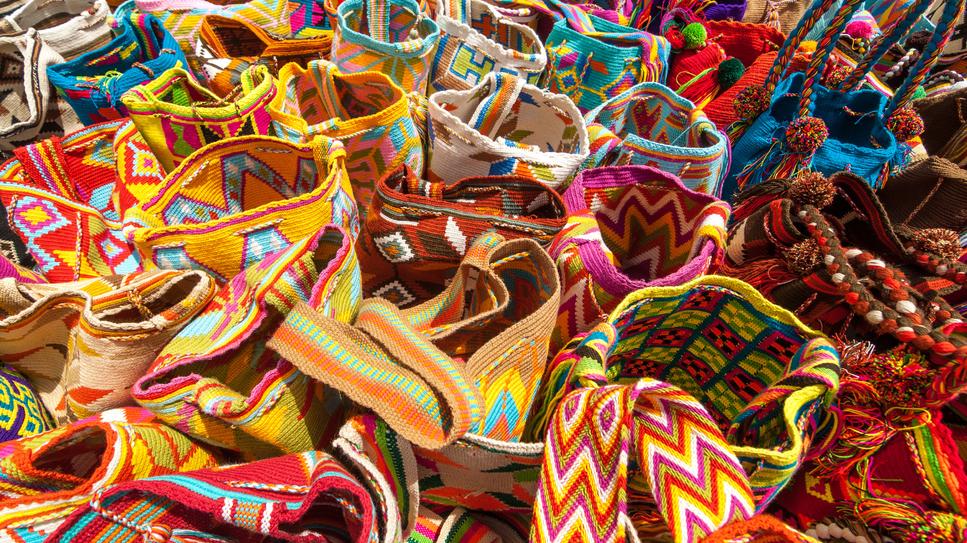 Colorful woven bags with various intricate patterns displayed closely together.