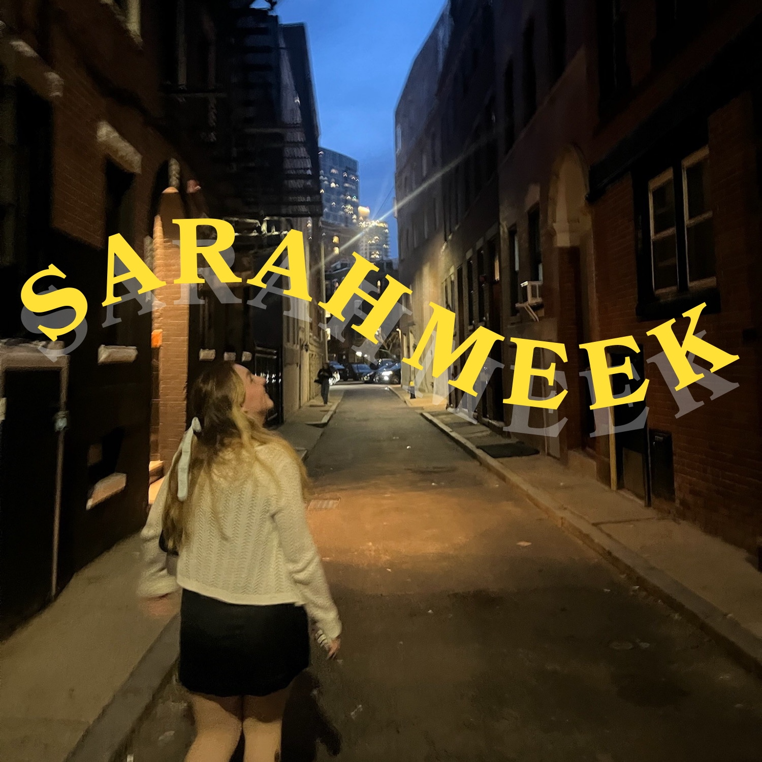 A woman walking in an alley at dusk, with tall city buildings in the background and a sign that reads 'Sarah Meek' in yellow 3D letters across the scene.
