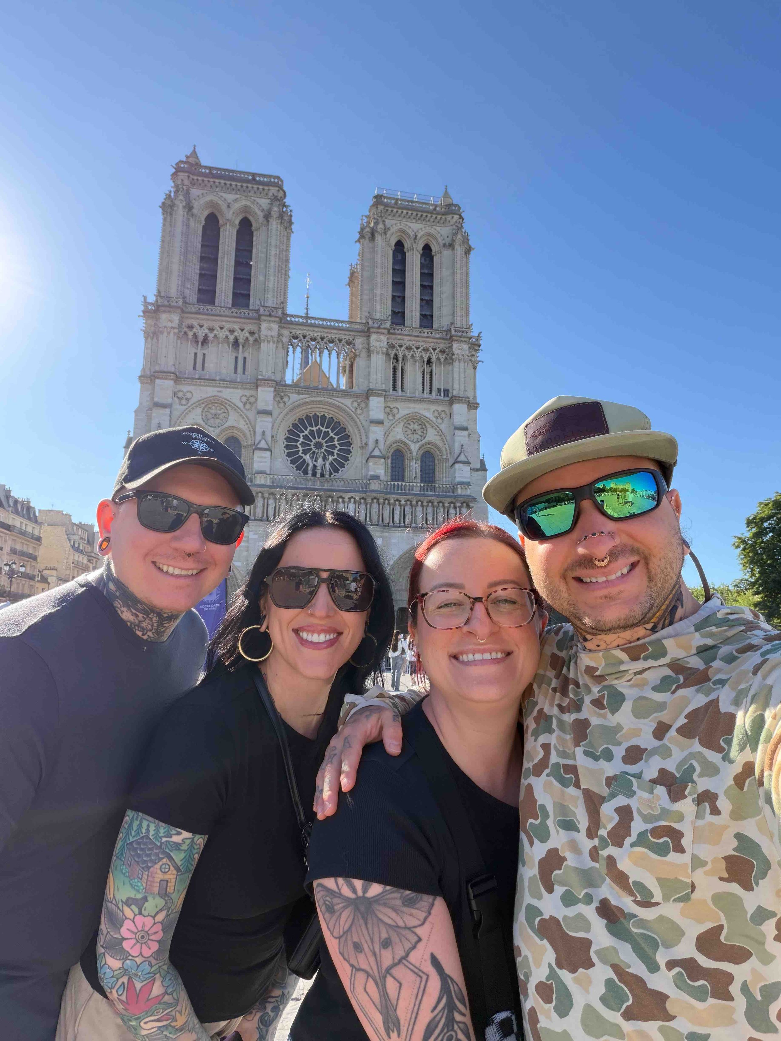 group image of Iggy Luppino, Keith, and Shannon from sink or swim tattoo and piercing enjoying traveling with Notre dame in the background