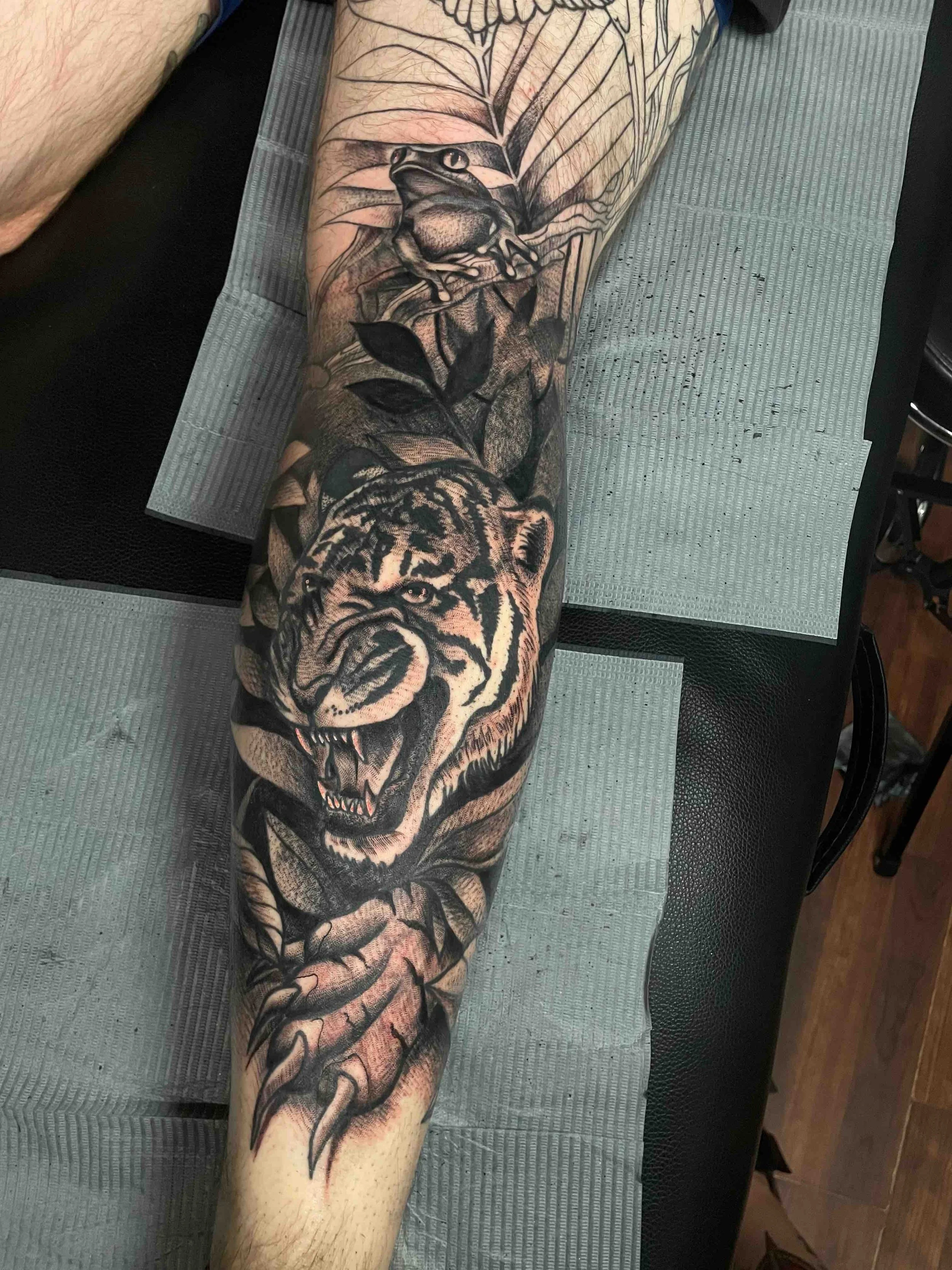 Black and grey tiger tattoo on a leg, portfolio work by Emily Quartley at Sink or Swim Tattoo and Piercing in Niagara Falls, NY