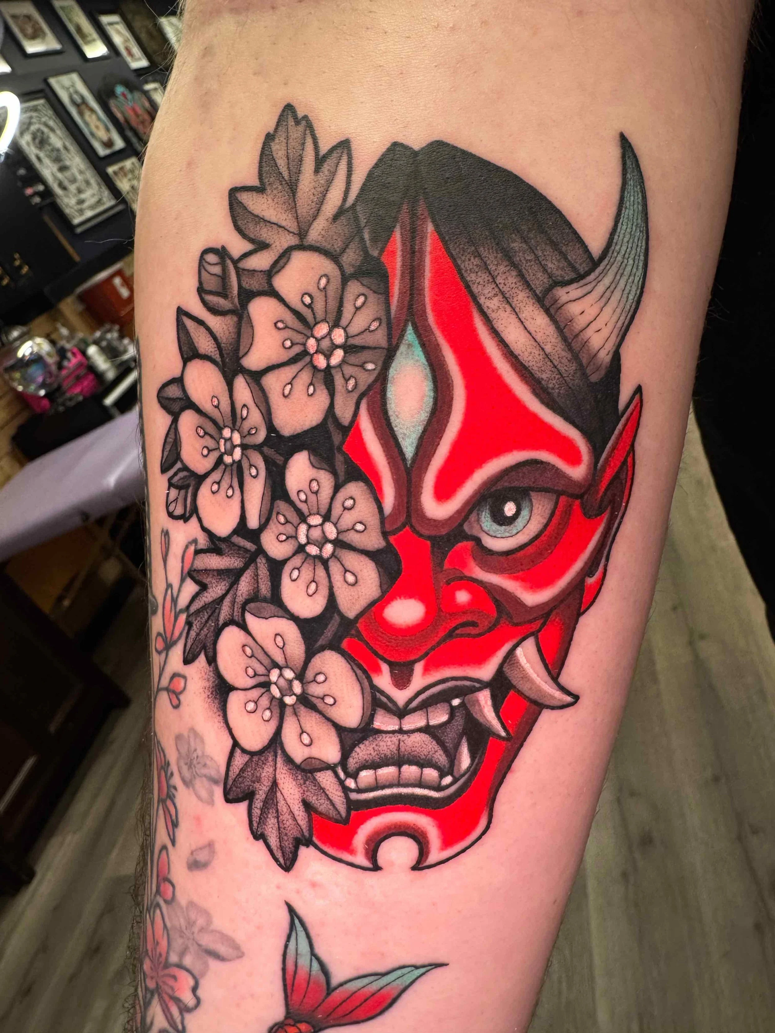 Japanese style hanya mask and flowers tattoo in color with black and grey portfolio work by Keith Kuzara at Sink or Swim Tattoo and Piercing in Niagara Falls NY
