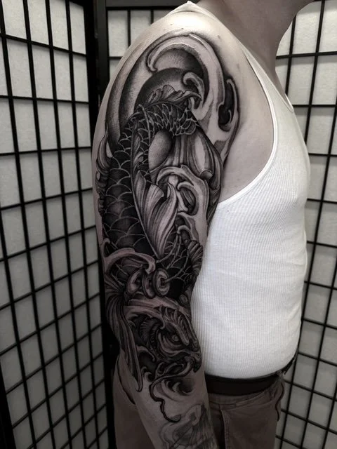 dark art black and grey japanese koi fish arm tattoo , portfolio work by Jordy Levea at sink or swim tattoo and piercing in Niagara Falls, ny