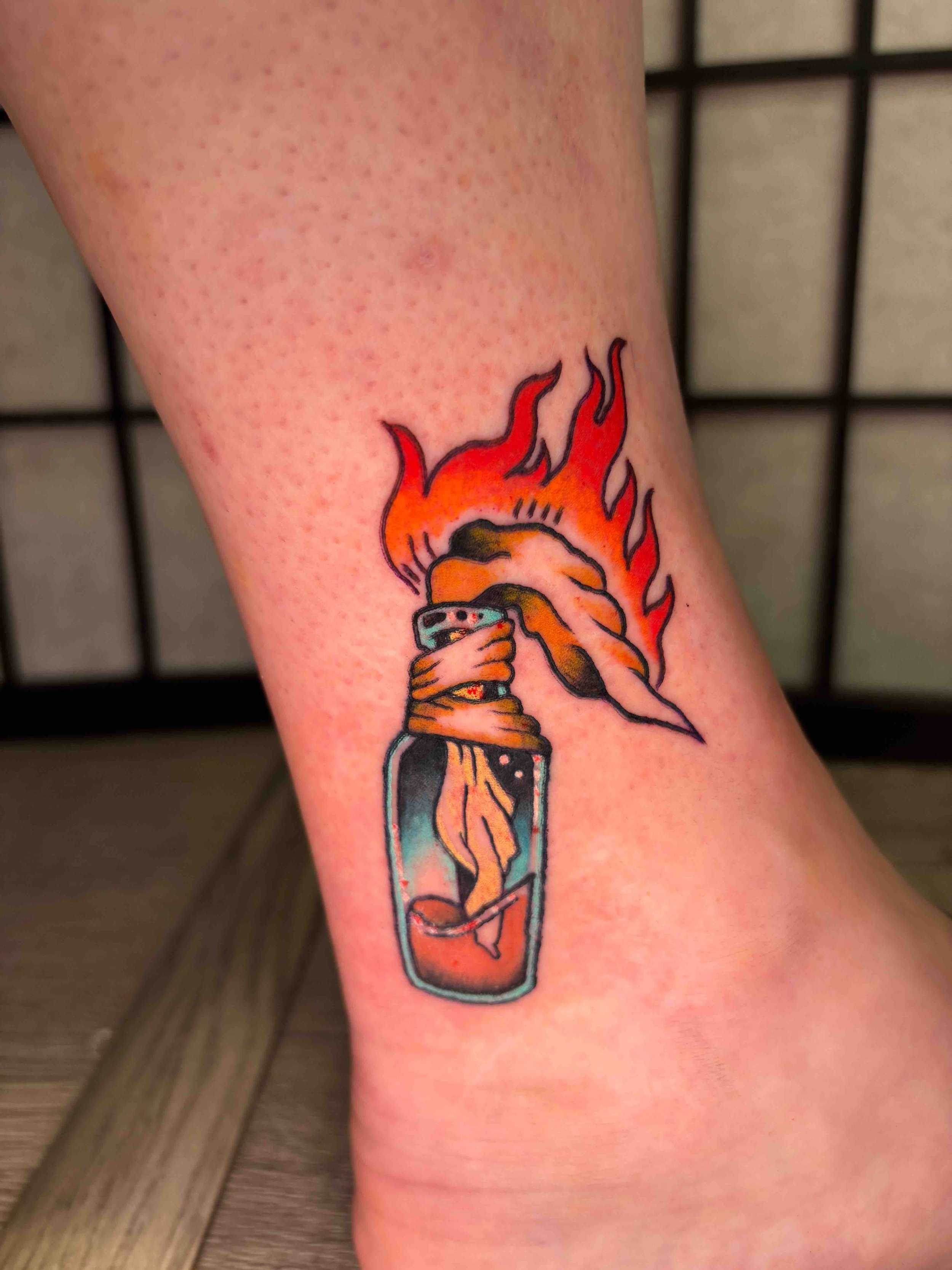 American Traditional Molotov cocktail tattoo above the ankle in color by AK Zaionz at Sink or Swim in Niagara Falls NY