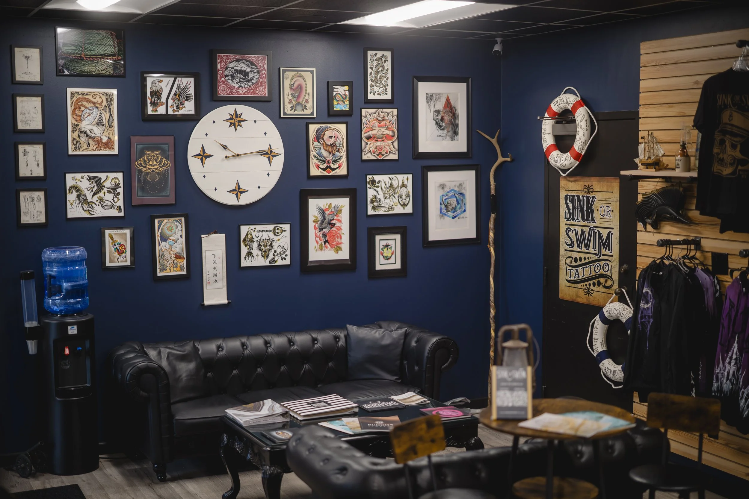 The comfortable client waiting area and custom tattoo flash art gallery wall inside Sink or Swim Tattoo in Niagara Falls near Buffalo NY