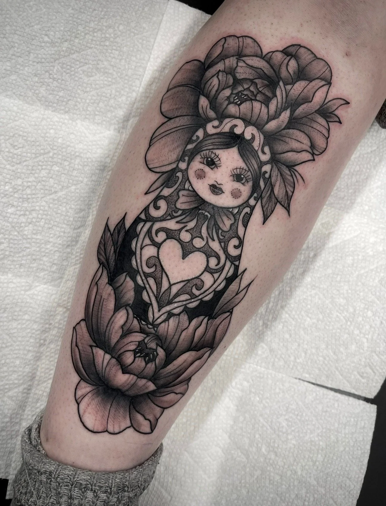 black and grey style tattoo with peonies and nesting doll , portfolio work by Brooke Canzoneri at sink or swim tattoo and piercing in Niagara Falls, ny