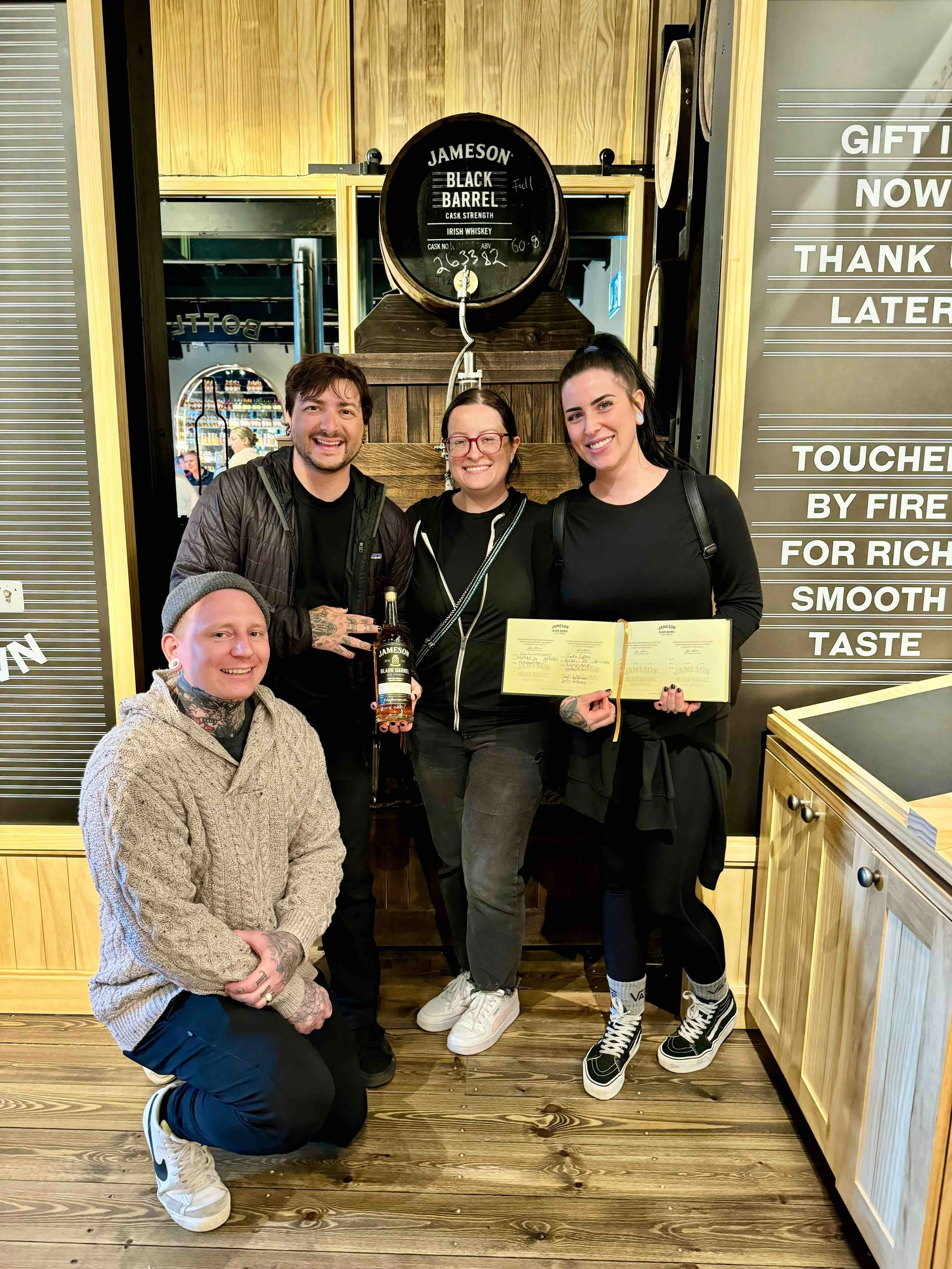 Iggy Luppino with Keith, Shannon, and jenn while holding a bottle of whiskey at the Jamison distillery in ireland