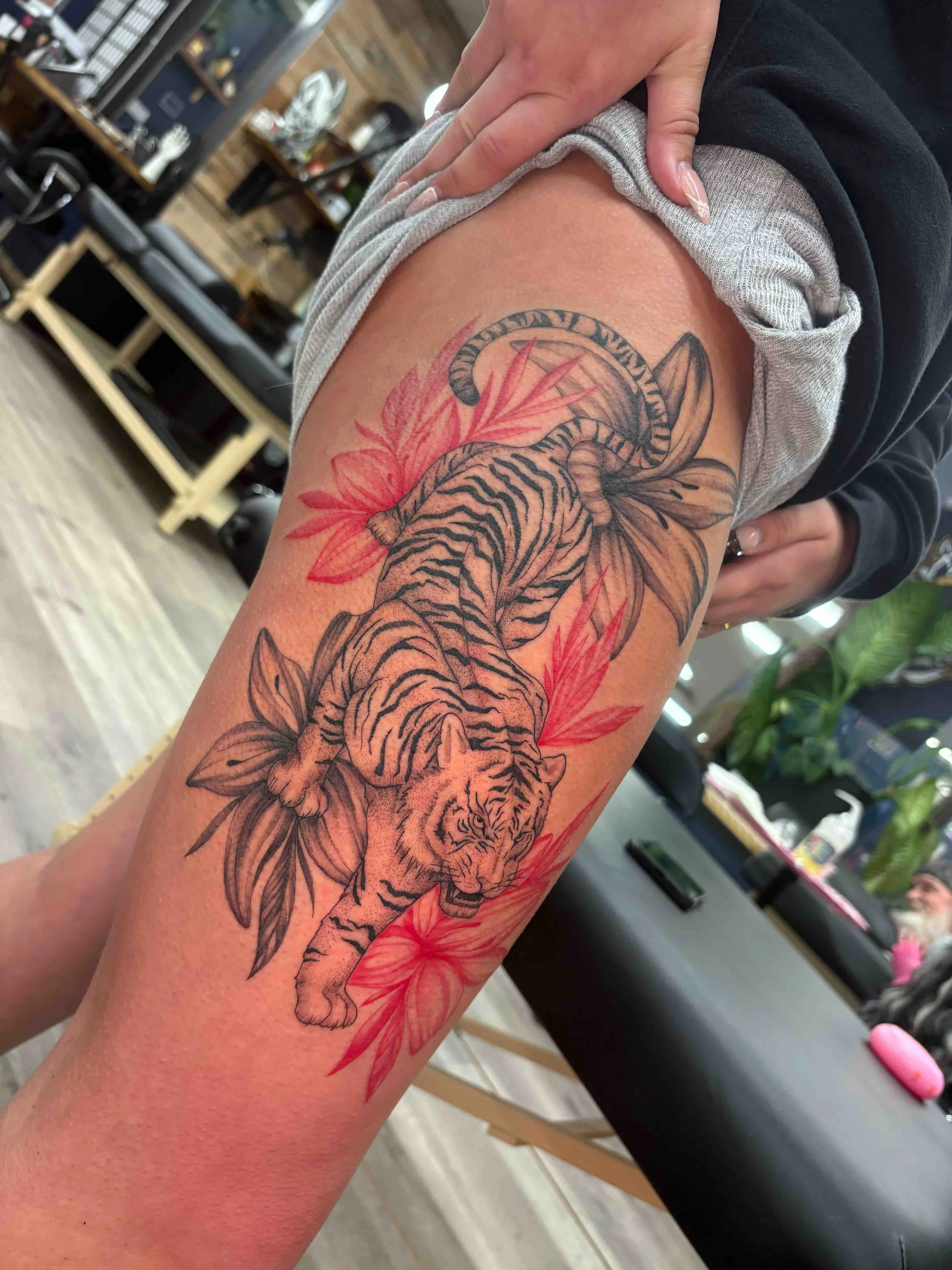 black and red illustrative thigh tattoo , portfolio work by Brooke Canzoneri at sink or swim tattoo and piercing in Niagara Falls, ny