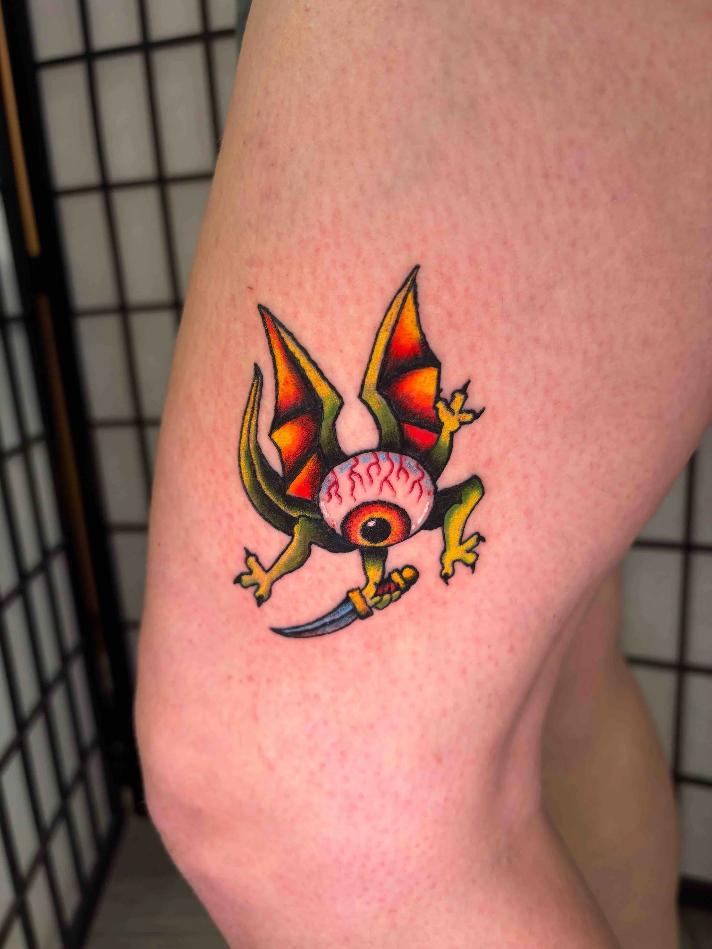 American Traditional eye demon color tattoo on lower thigh by AK Zaionz at Sink or Swim in Niagara Falls NY