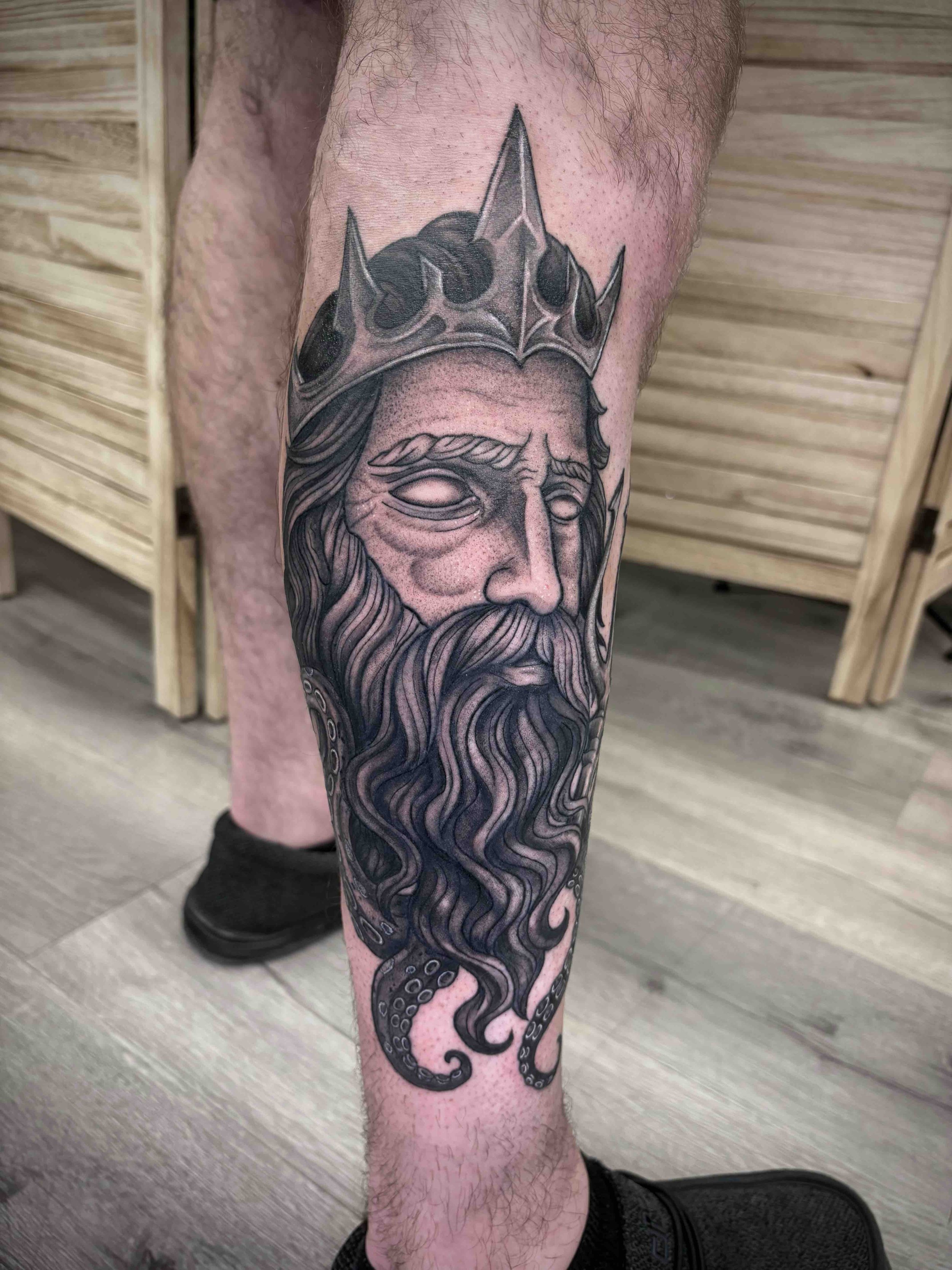 black and grey tattoo of Poseidon on side of calf , portfolio work by Brooke Canzoneri at sink or swim tattoo and piercing in Niagara Falls, ny