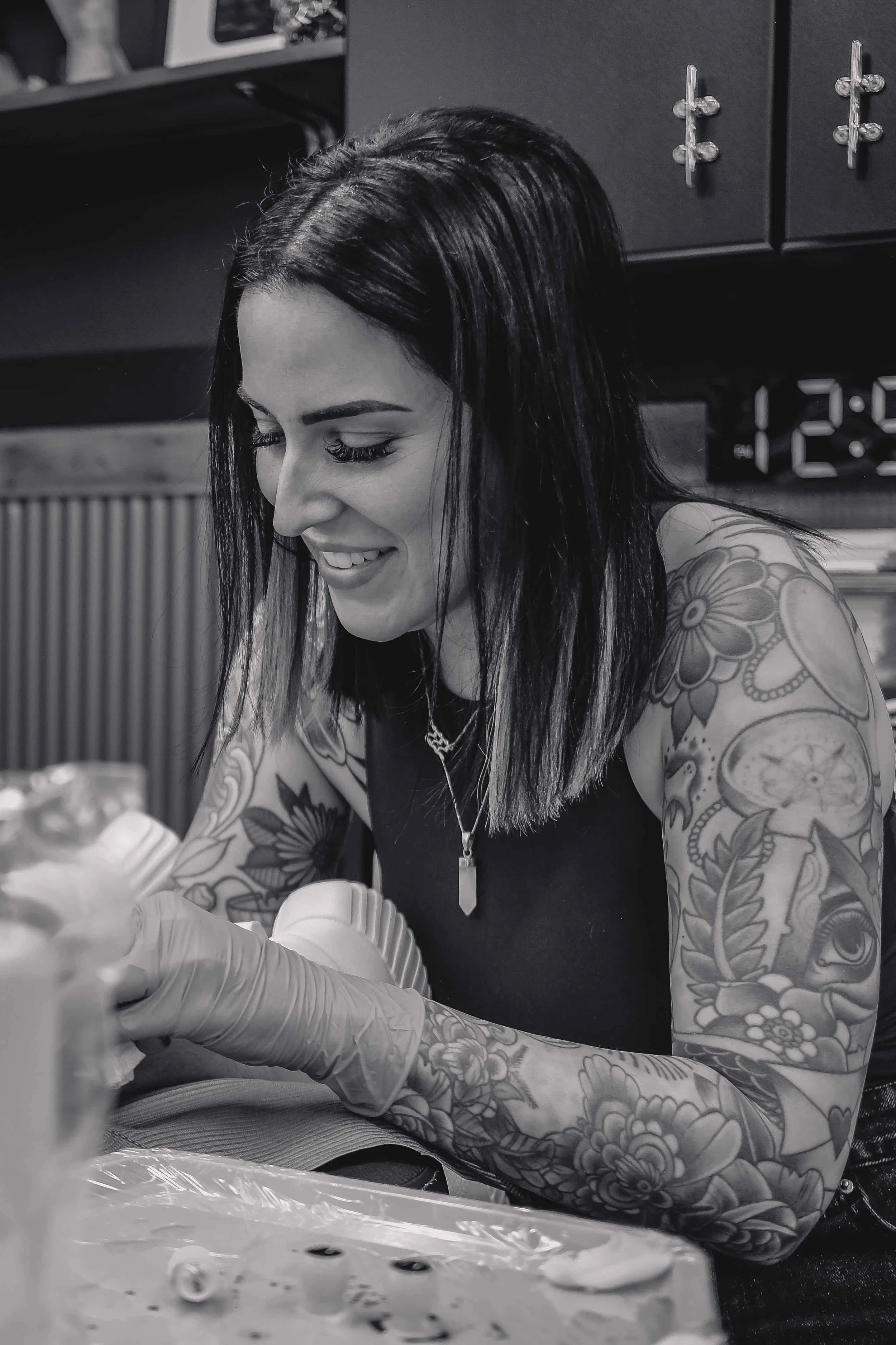 Shannon smiling while tattooing a client at sink or swim in Niagara Falls, ny