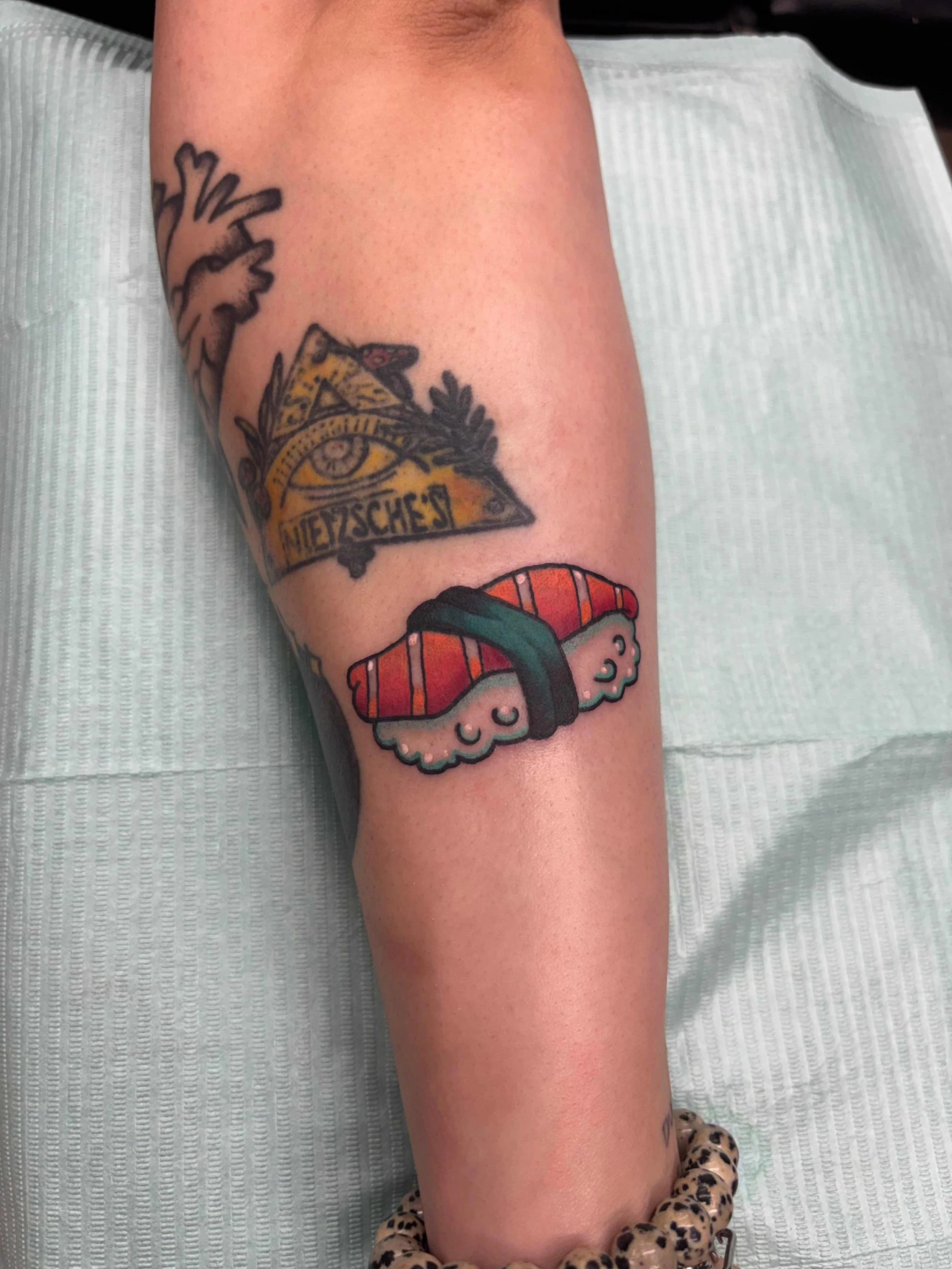 Neo traditional color sushi tattoo above the wrist by AK Zaionz at Sink or Swim in Niagara Falls NY
