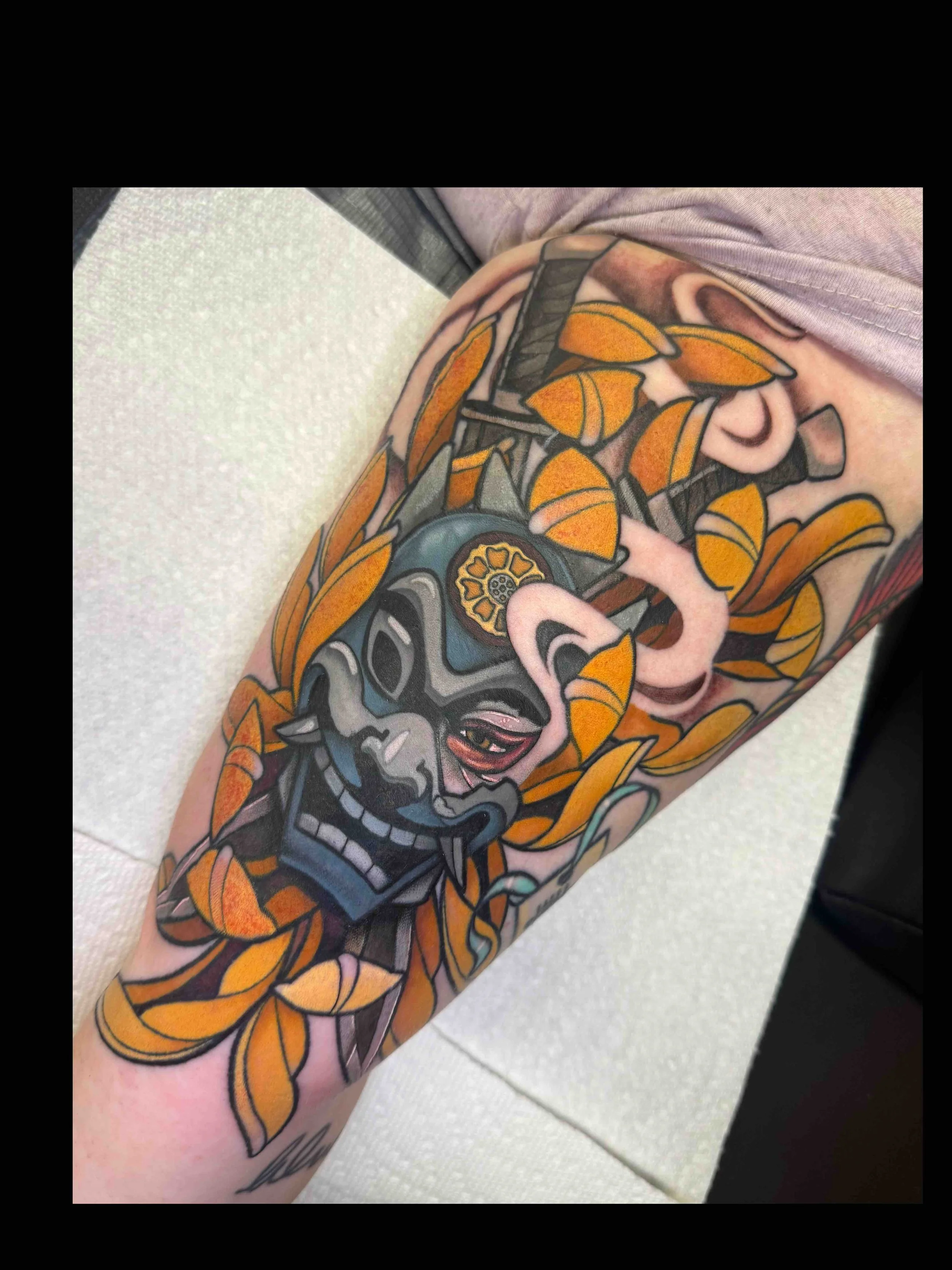 Neo traditional Avatar mask and crysanthemum tattoo in color portfolio work by Shannon Kuzara at Sink or Swim Tattoo and Piercing in Niagara Falls NY