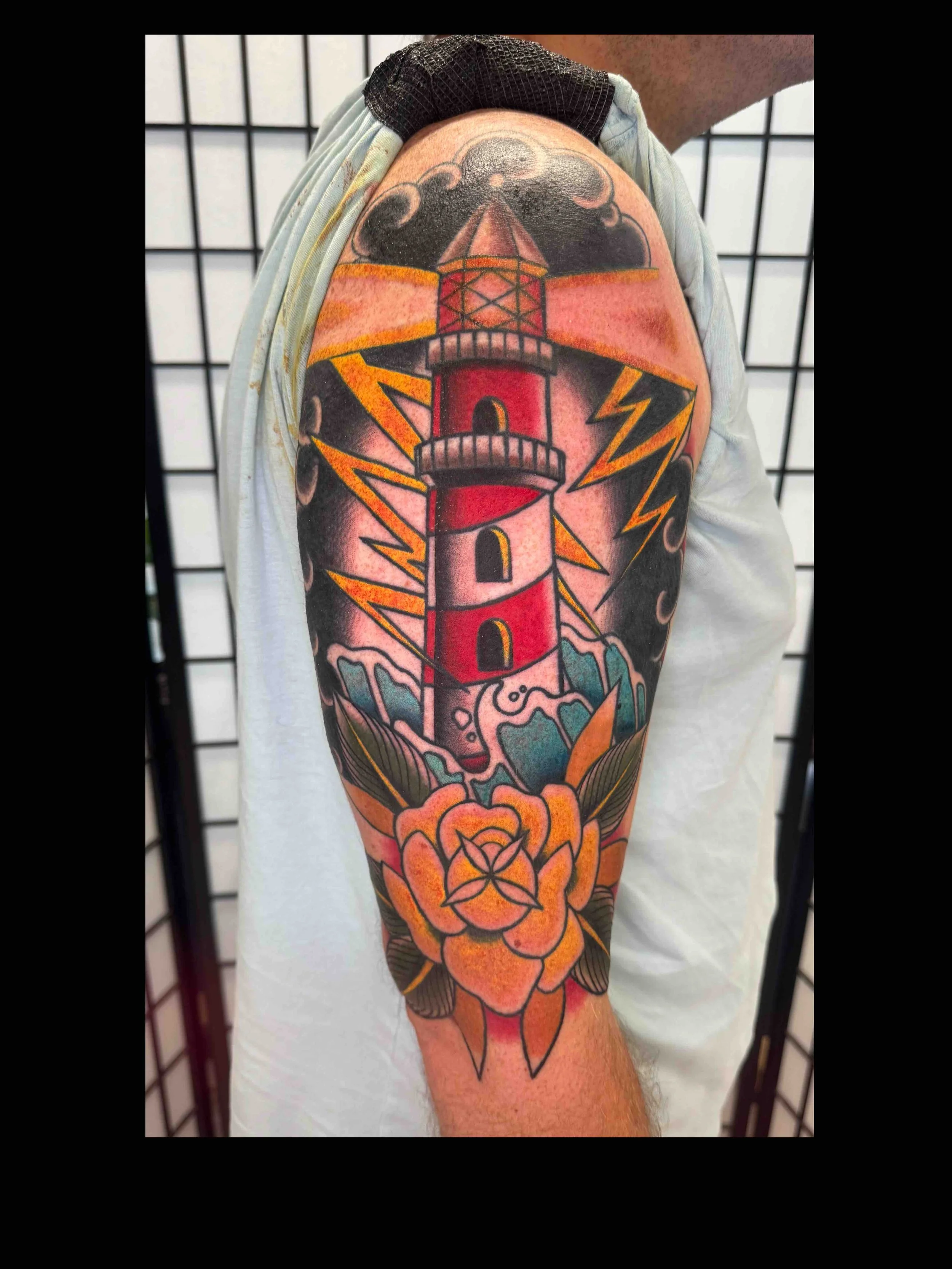 Traditional stormy lighthouse nautical tattoo in color portfolio work by Shannon Kuzara at Sink or Swim Tattoo and Piercing in Niagara Falls NY