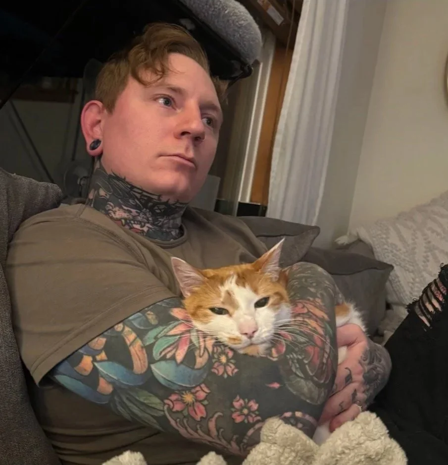 Keith sitting on a couch with his cat twist
