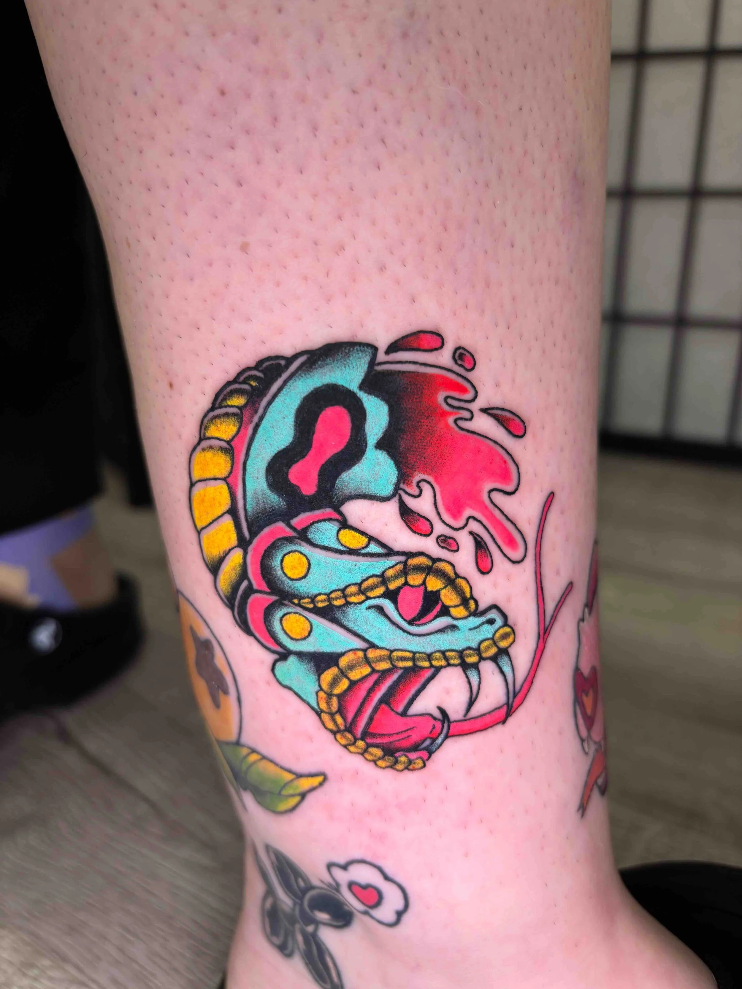 American Traditional severed snake head on an ankle in color by AK Zaionz at Sink or Swim in Niagara Falls NY