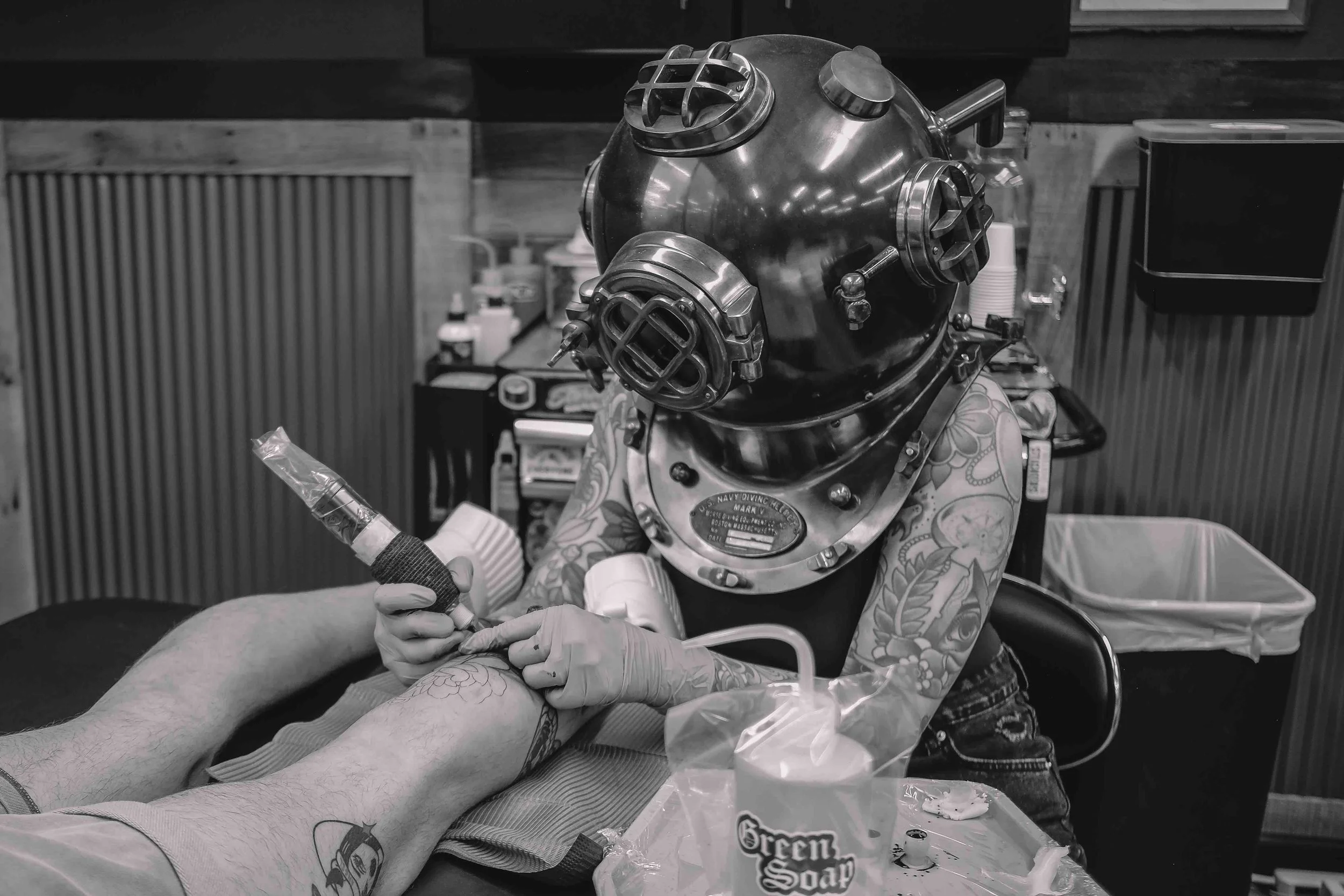 shannon with a divers helmet while in front of her tattoo booth at sink or swim