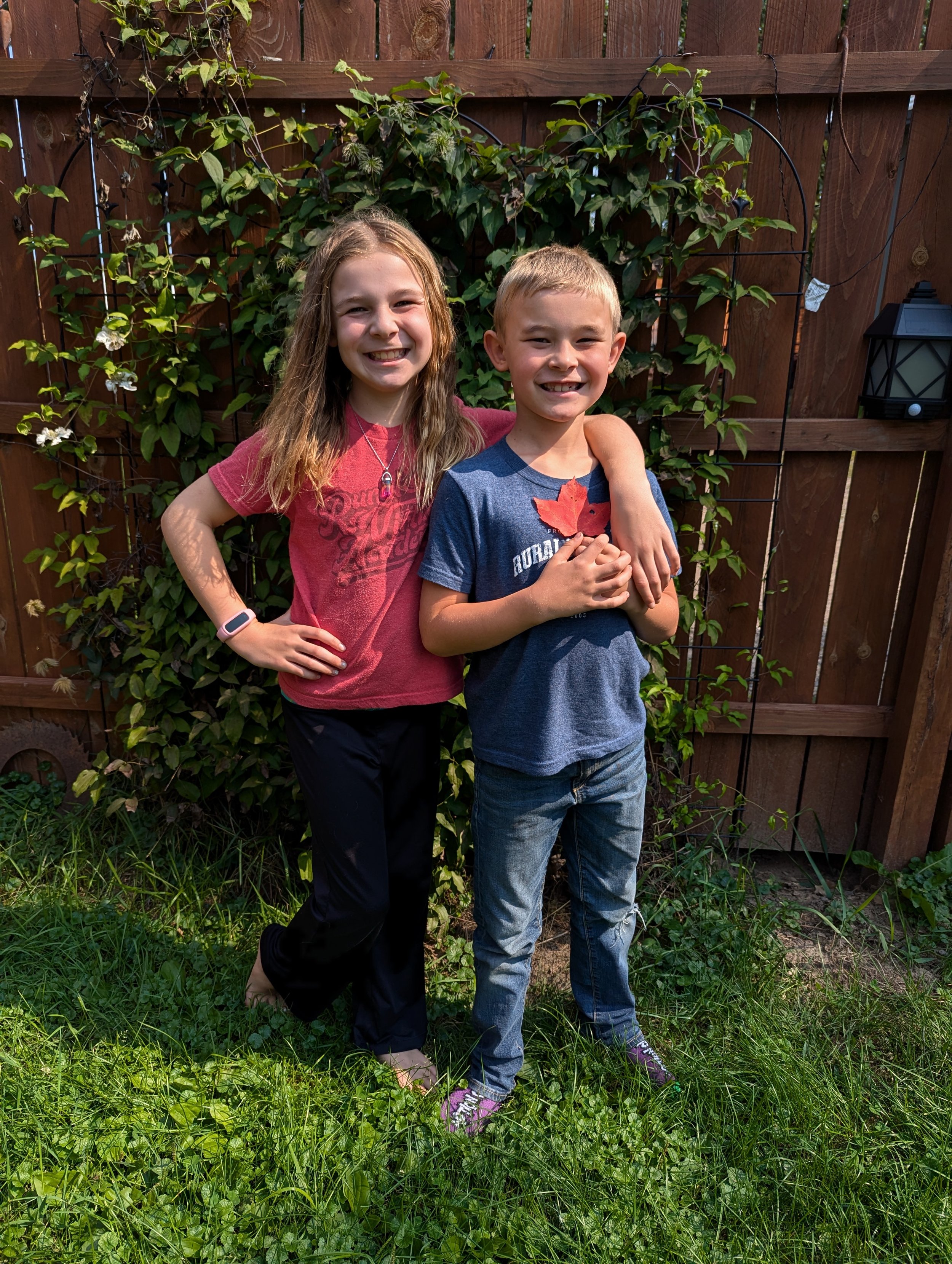 Brother Sister in front of fence