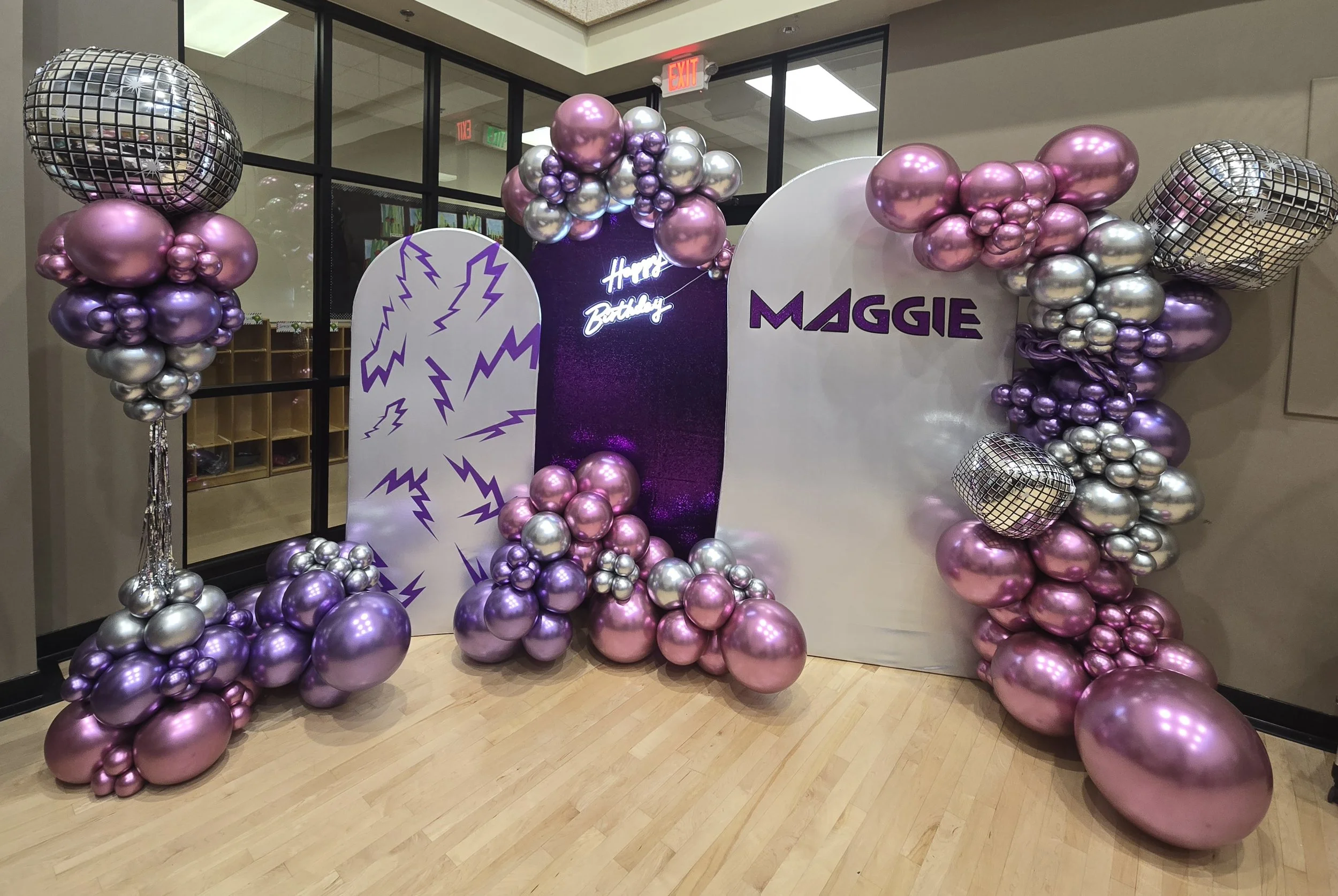 shiny balloons in a Kpop demon hunters theme with pink, purple and silver balloons and Maggie on the backdrop with happy birthday neon sign