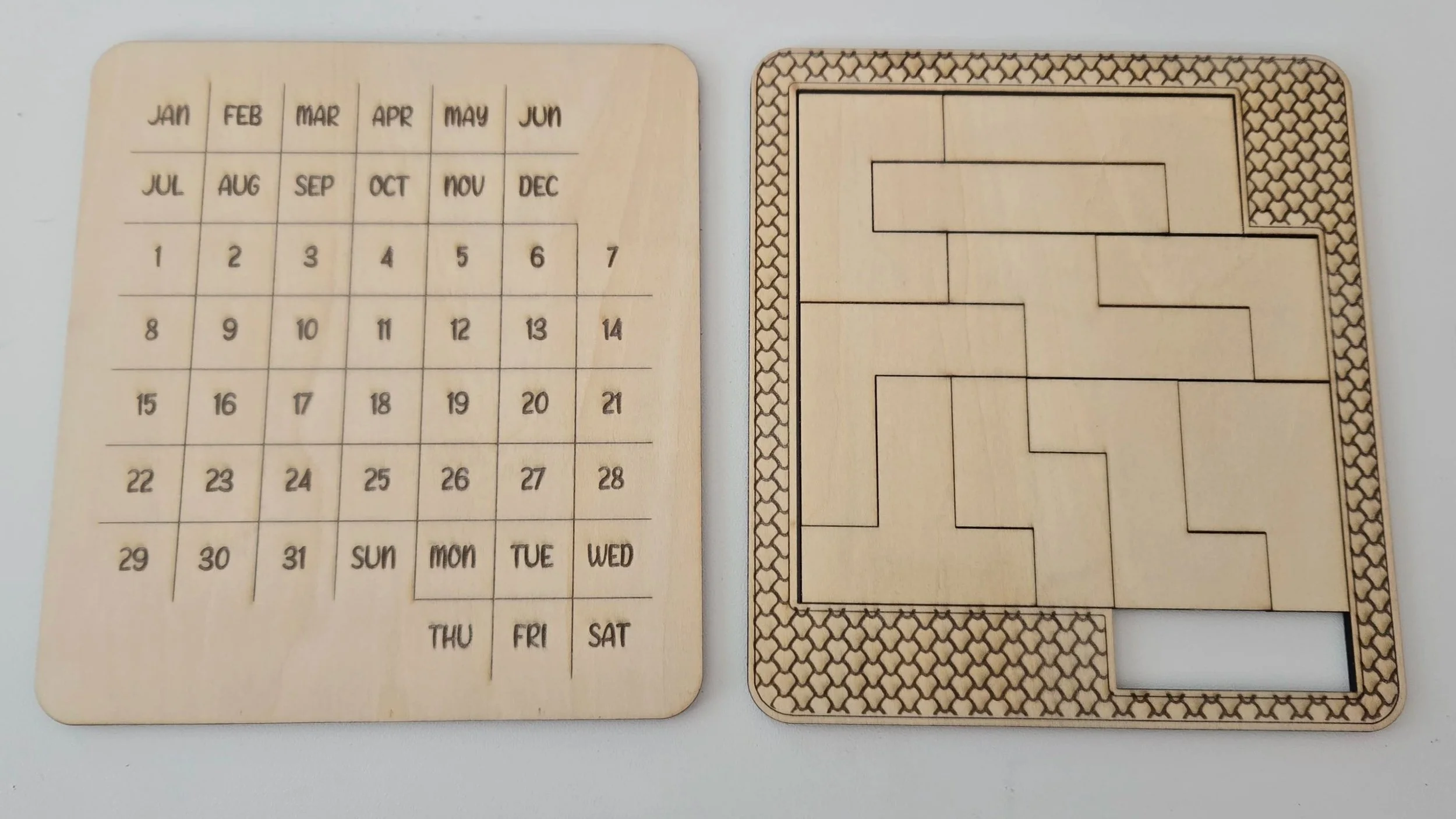 Wooden perpetual calendar puzzle engraved with months, dates, and days of the week, beside its puzzle pieces in a honeycomb-pattern tray