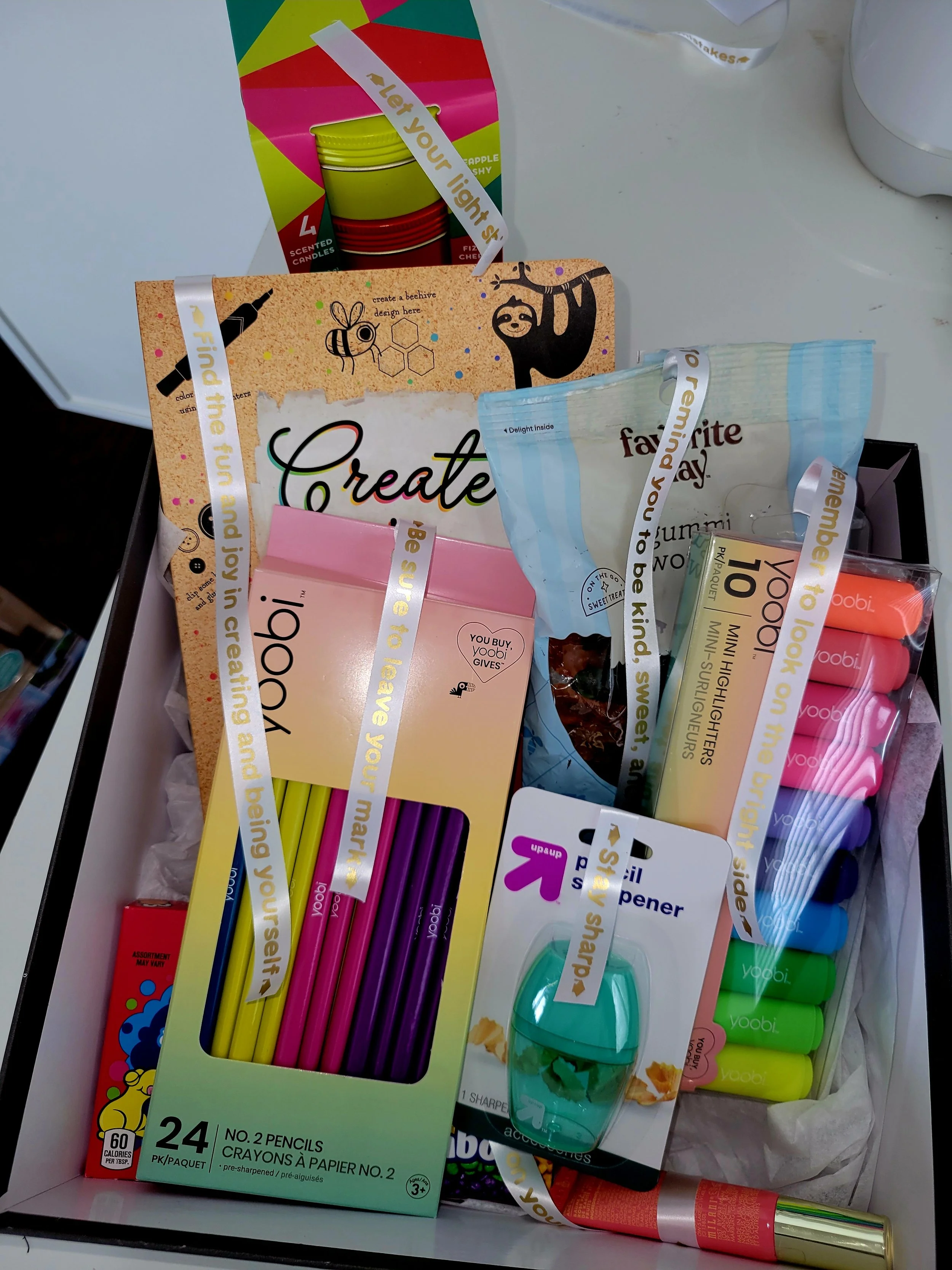 High school survival kit gift box with pencils, highlighters, a notebook, a pencil sharpener, and other school supplies