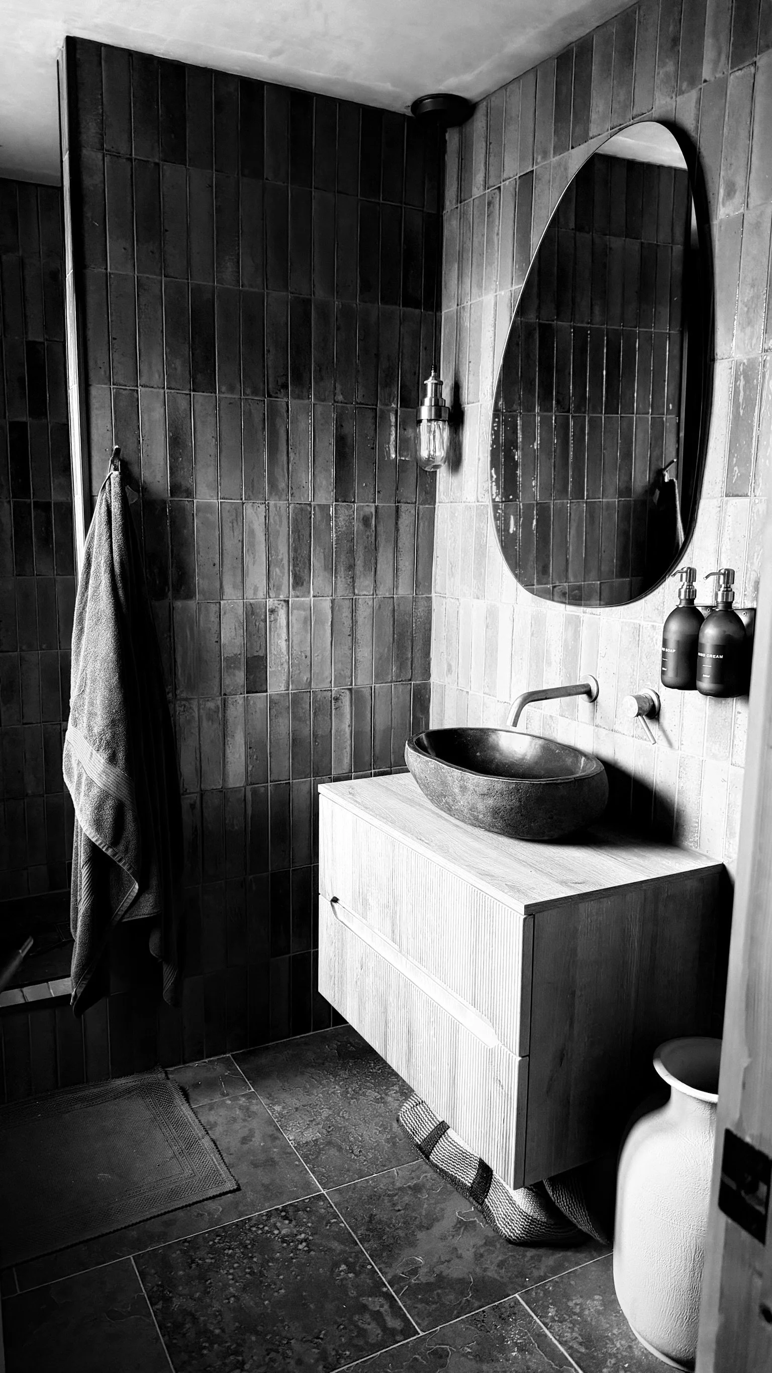 SHOWER ROOM WITH MANDARIN STONE TILES WOODEN VANITY UNIT AND RIVER STONE BASIN