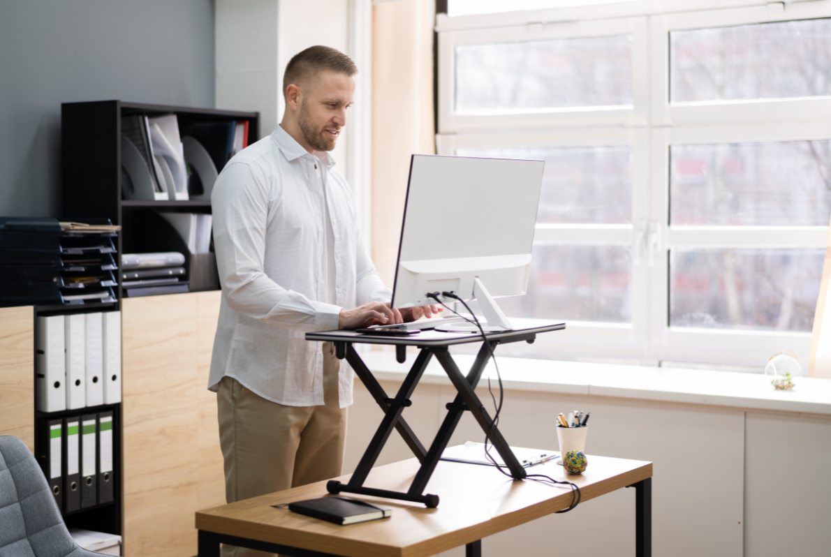 Man using laptop on standing desk in his office