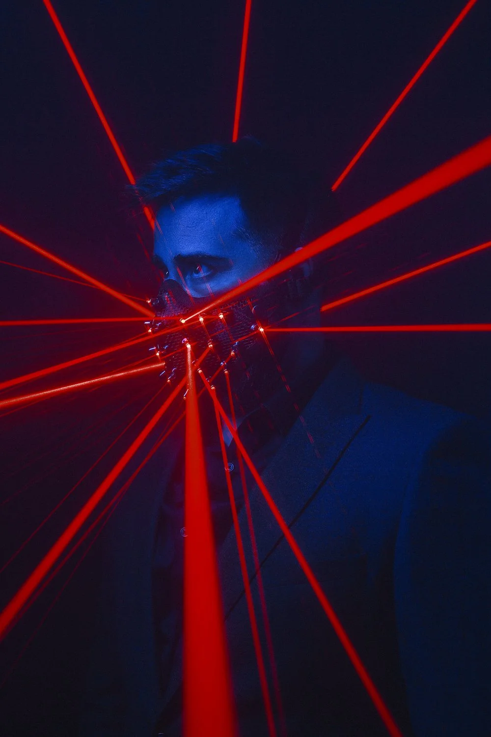 Music portrait: masked performer inside red laser beams