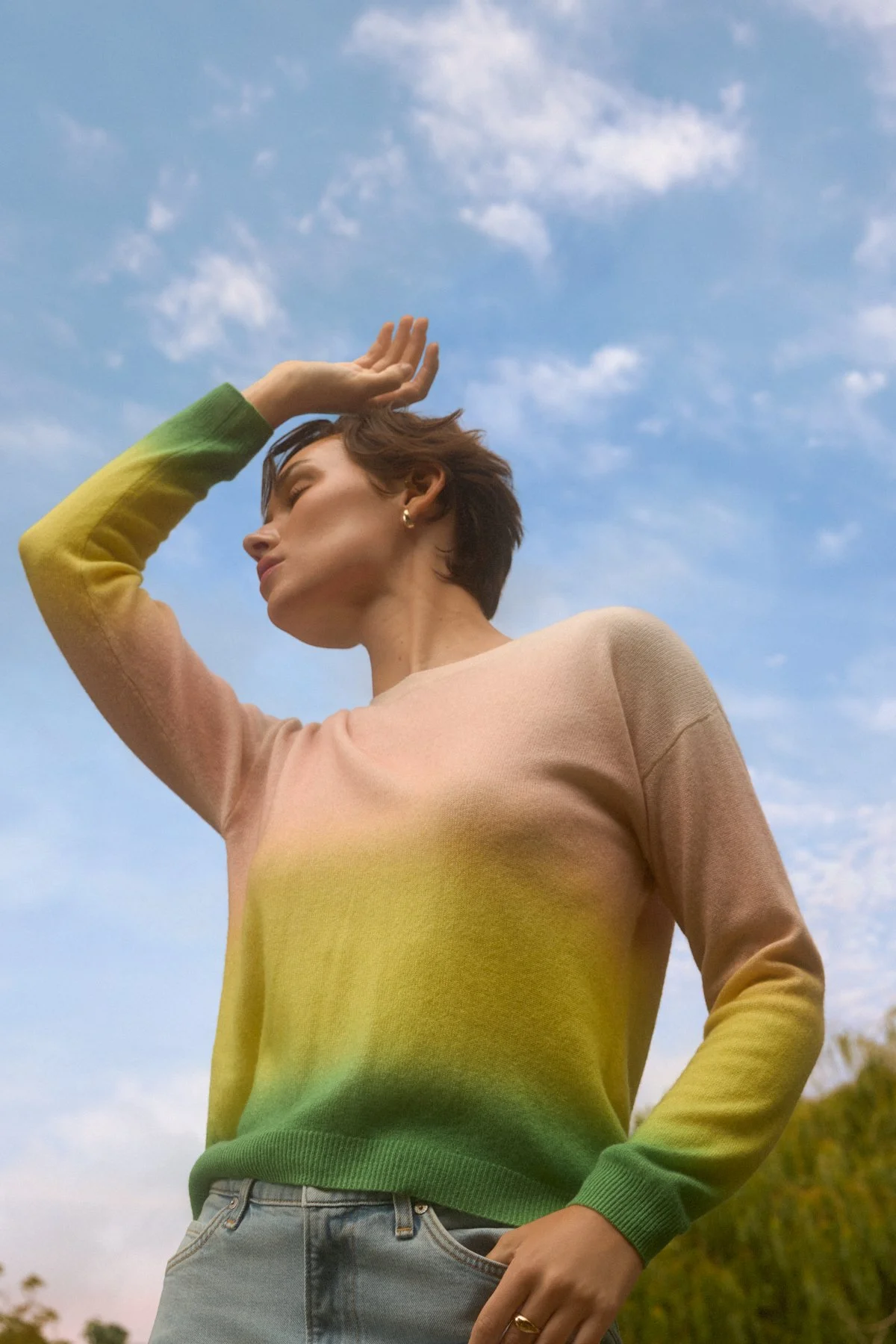 Knitwear lookbook: model in pearl earrings shot against a blue sky