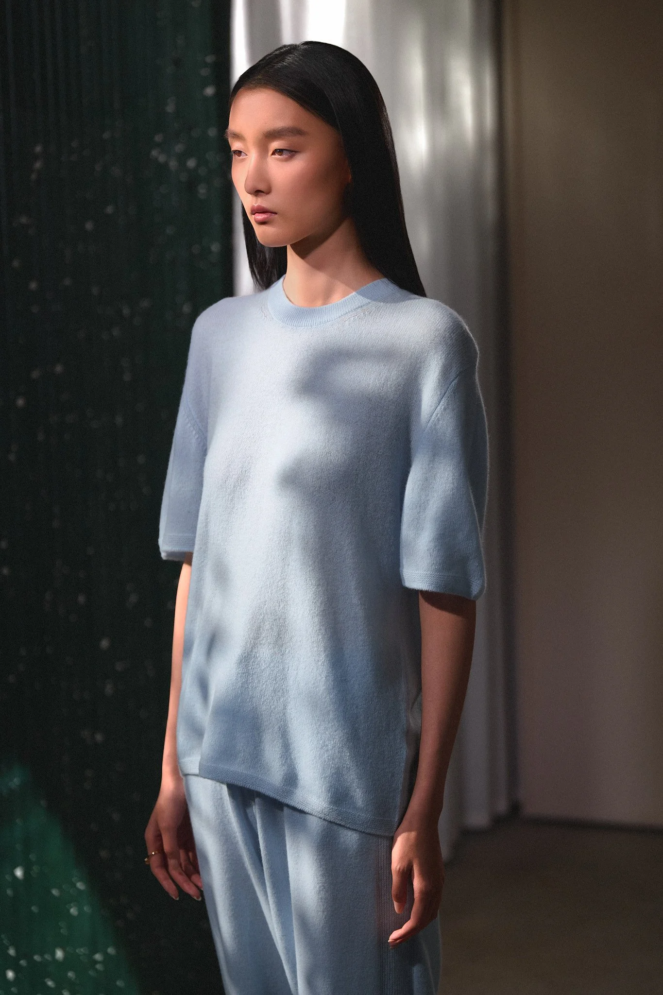 Fashion lookbook: model in a pale blue T-shirt and matching trousers
