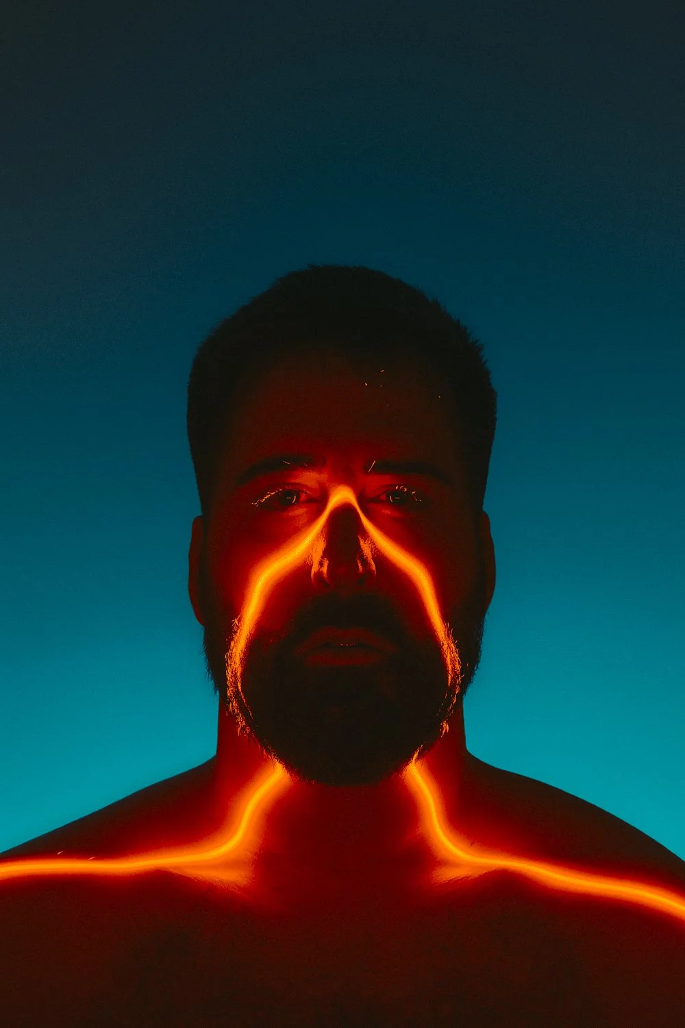 Music portrait: artist lit with glowing orange light across the face
