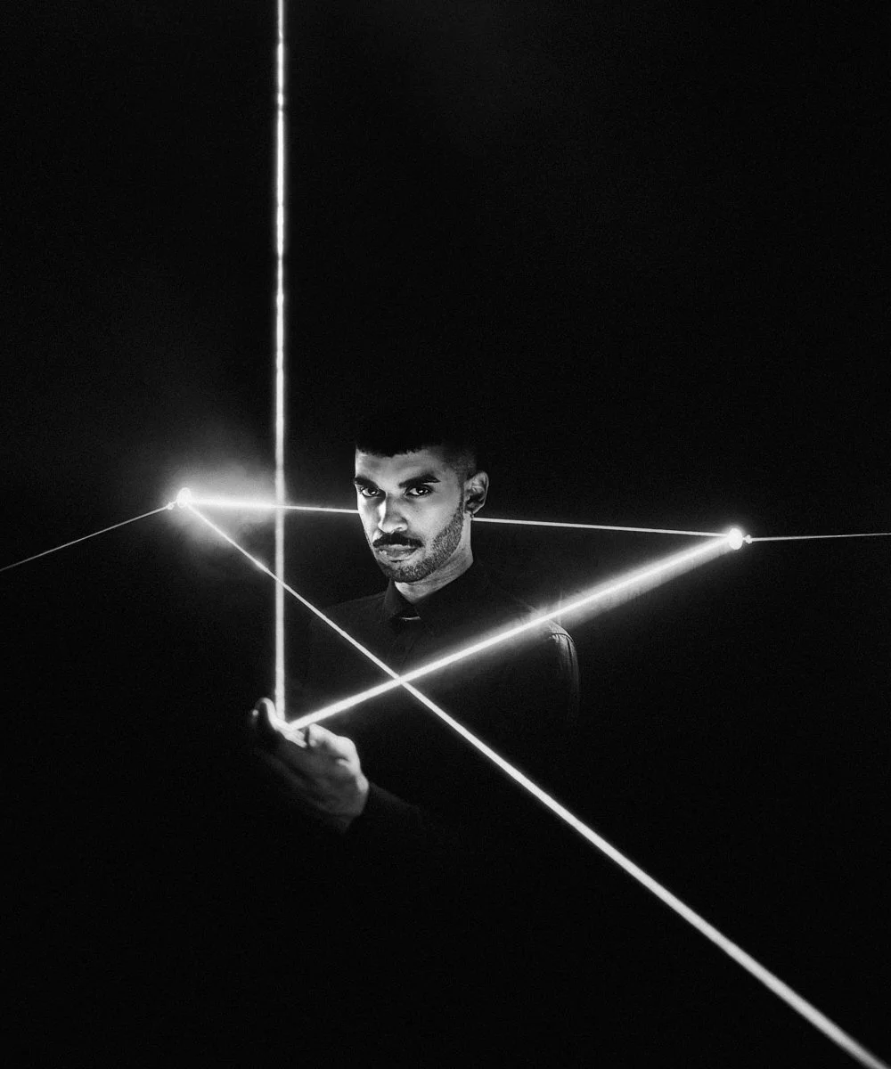 Music portrait: artist drawing geometric laser lines in the dark