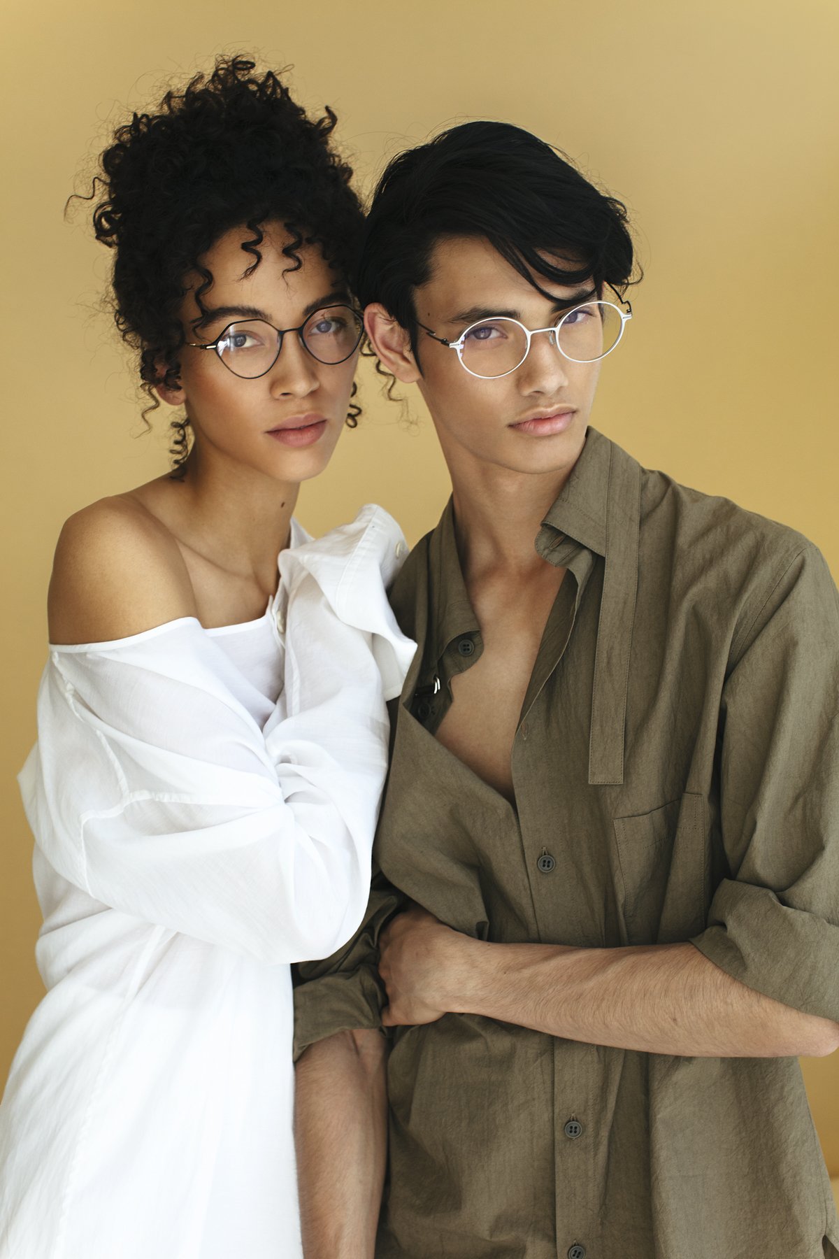 Eyewear campaign: two models in optical frames against beige
