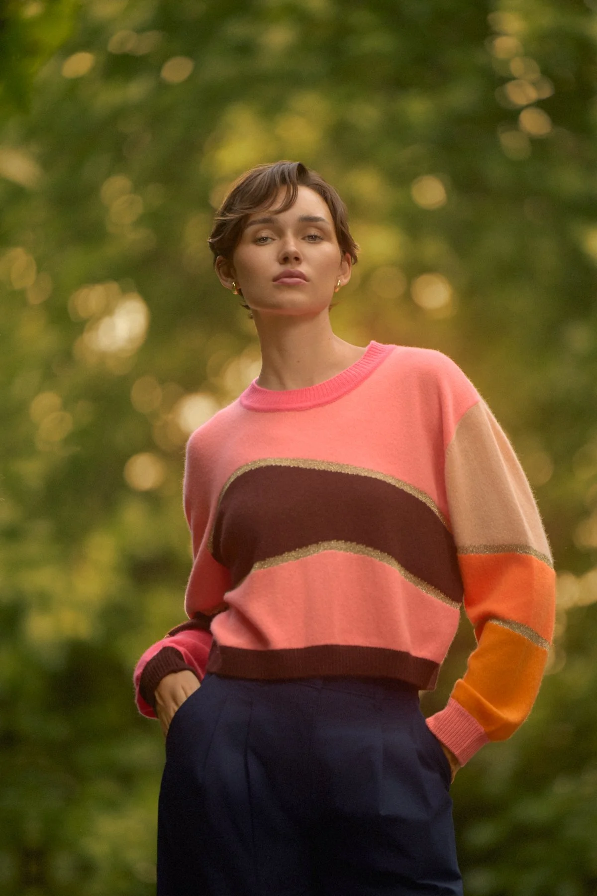 Knitwear lookbook: model in colour-block knitwear against blurred trees