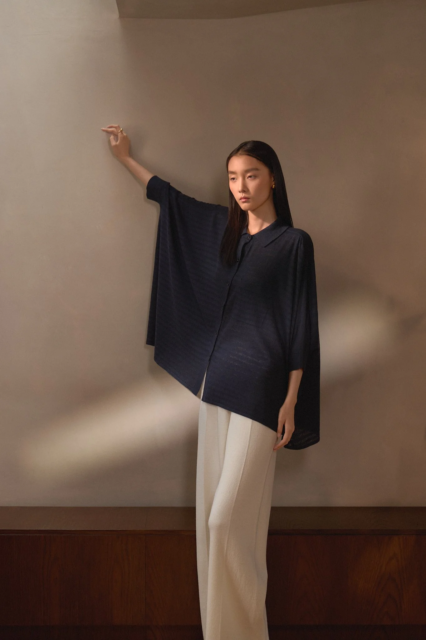 Fashion lookbook: navy shirt and beige trousers styled on a mannequin
