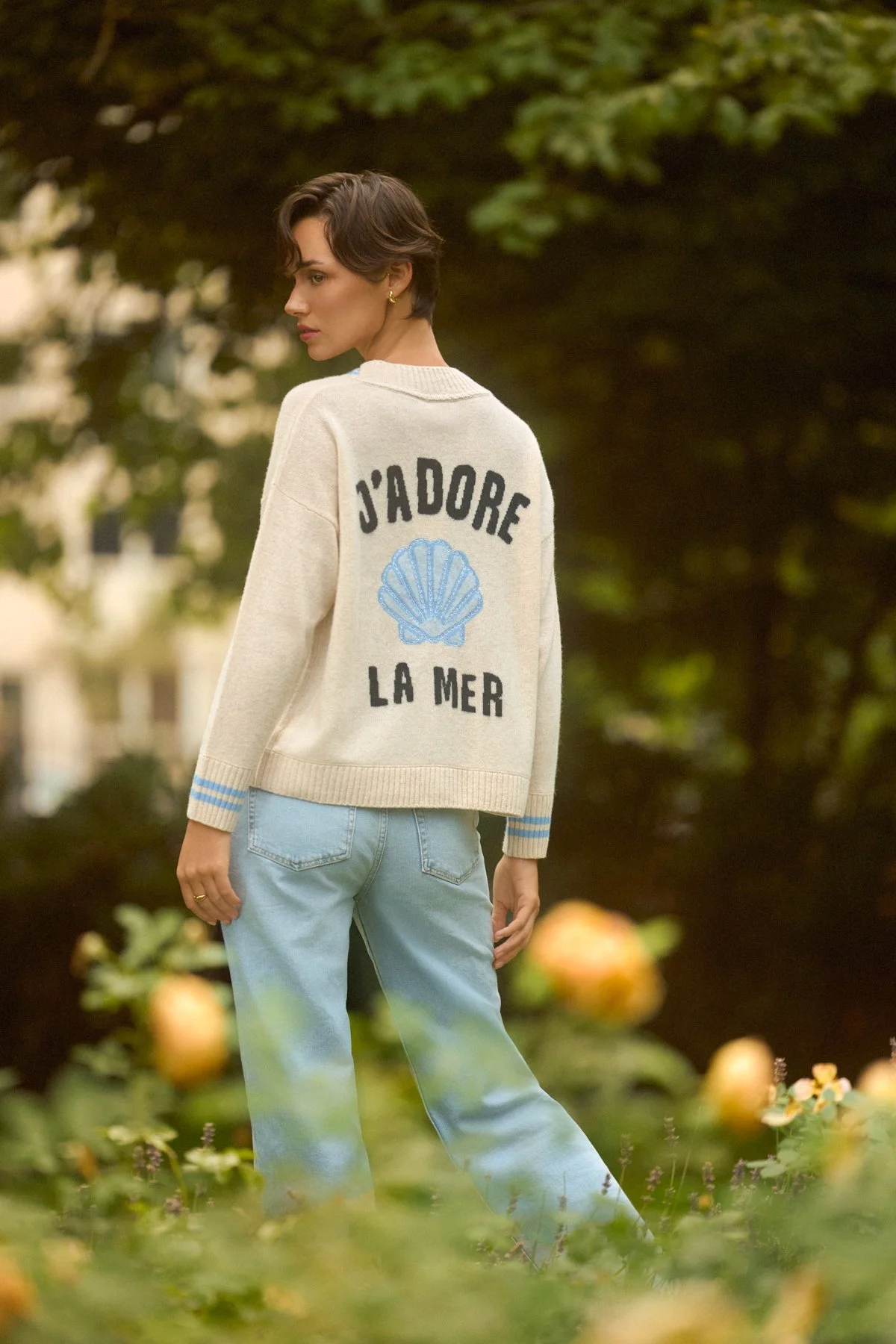Knitwear lookbook: model in a cream jumper with a blue seashell motif