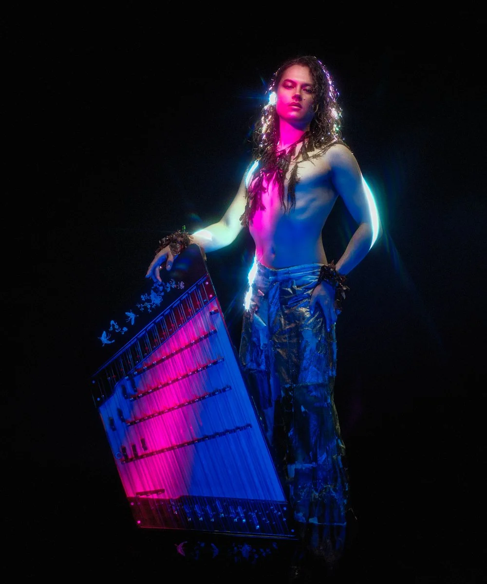 Music portrait: artist with long curls lit in vivid colour