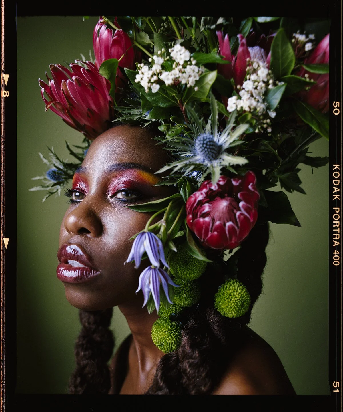 Floral studio portrait: headpiece of red blooms, baby’s breath and bellflowers