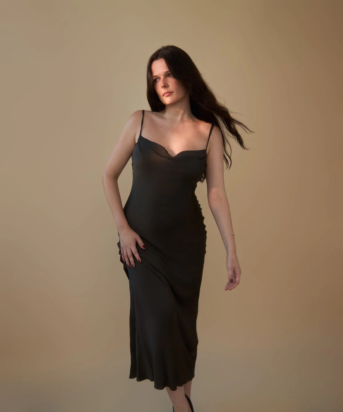 Model test: portrait in a black slip dress on beige