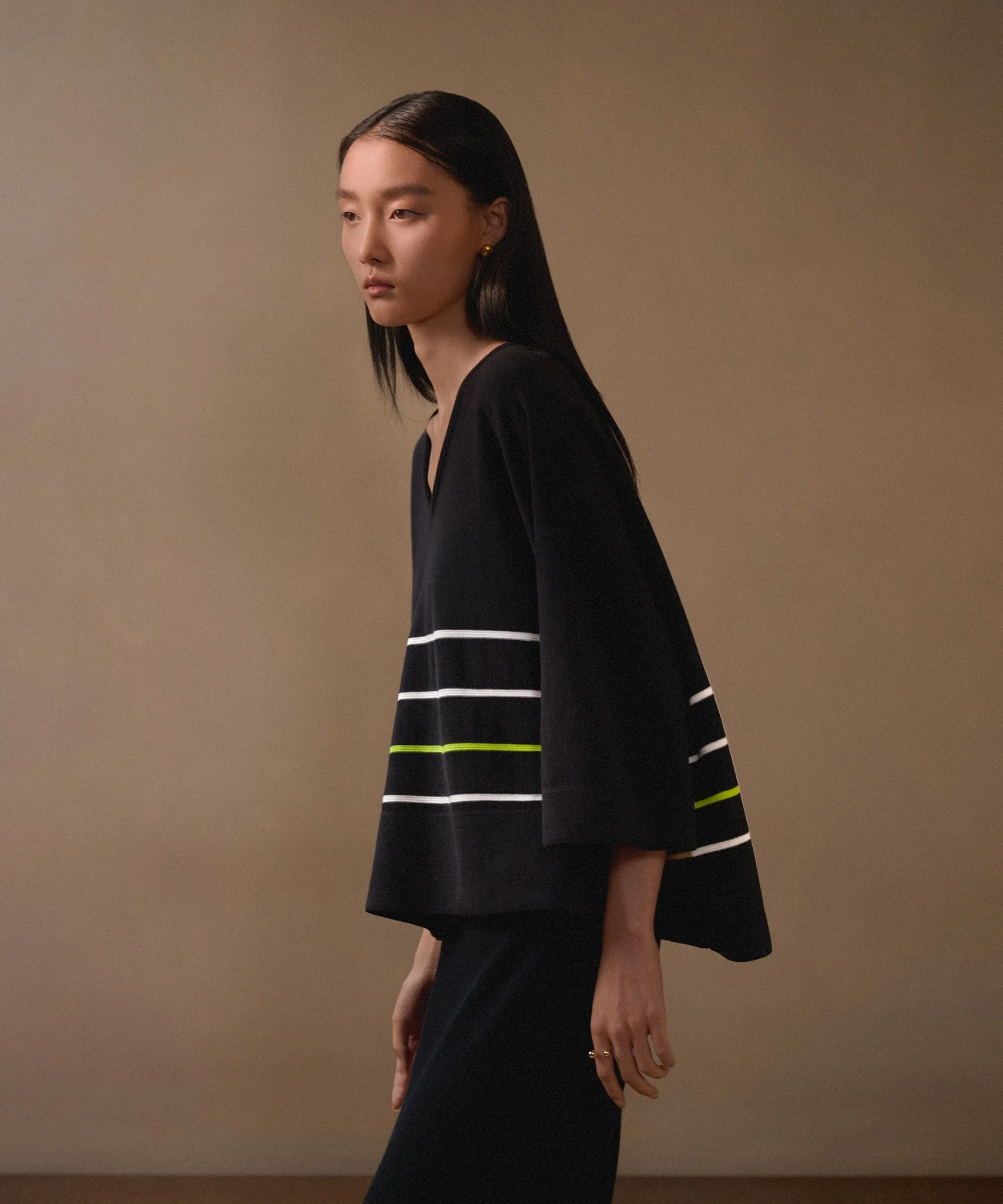 Fashion lookbook: model in a striped-hem black dress with gold jewellery