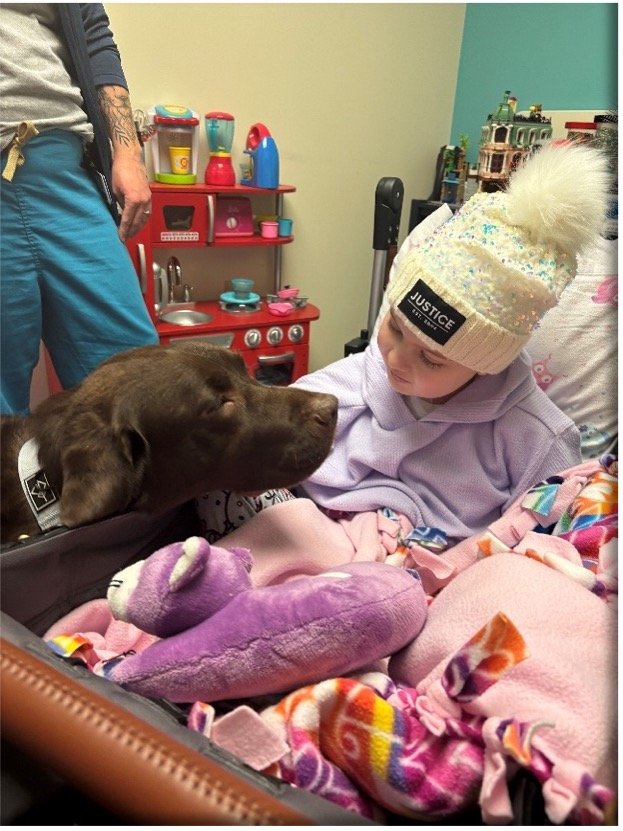 Nora during medical treatment with a Duo Dog providing comfort and support.