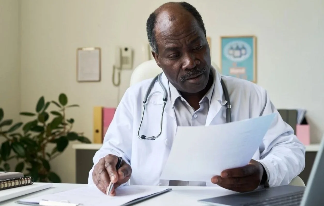 Physician reviewing documents while considering becoming a California Qualified Medical Evaluator