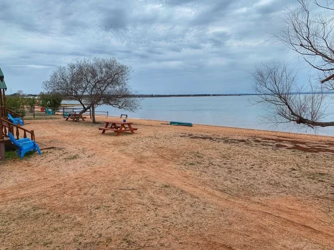 Exterior of Cabin 9 with green roof and porch near Lake Buchanan