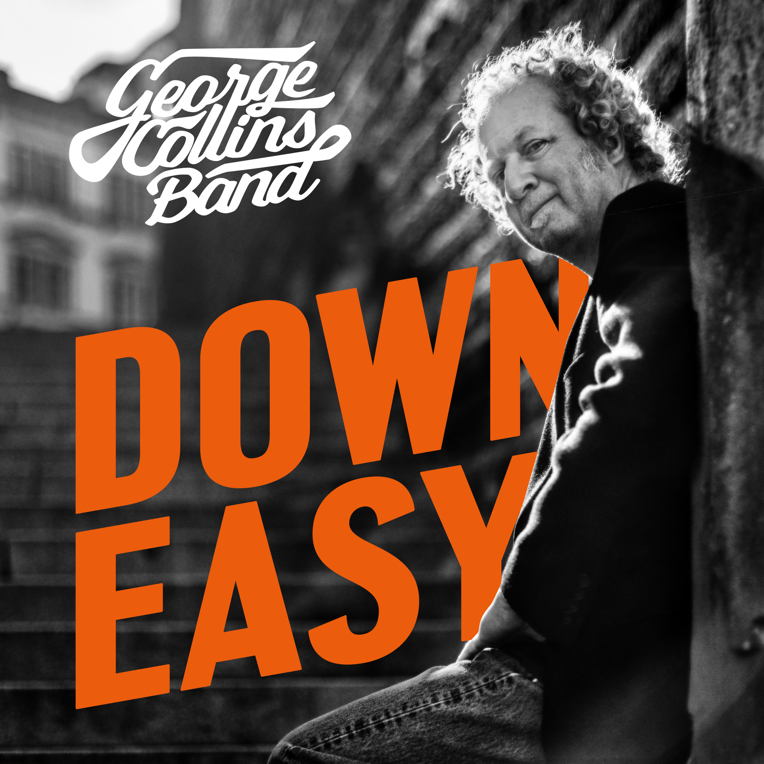 Black and white photo of a man with curly hair and a blazer, sitting outdoors on steps, with bold orange text saying 'DOWN' and white cursive text saying 'George Hollings Band' over the image.