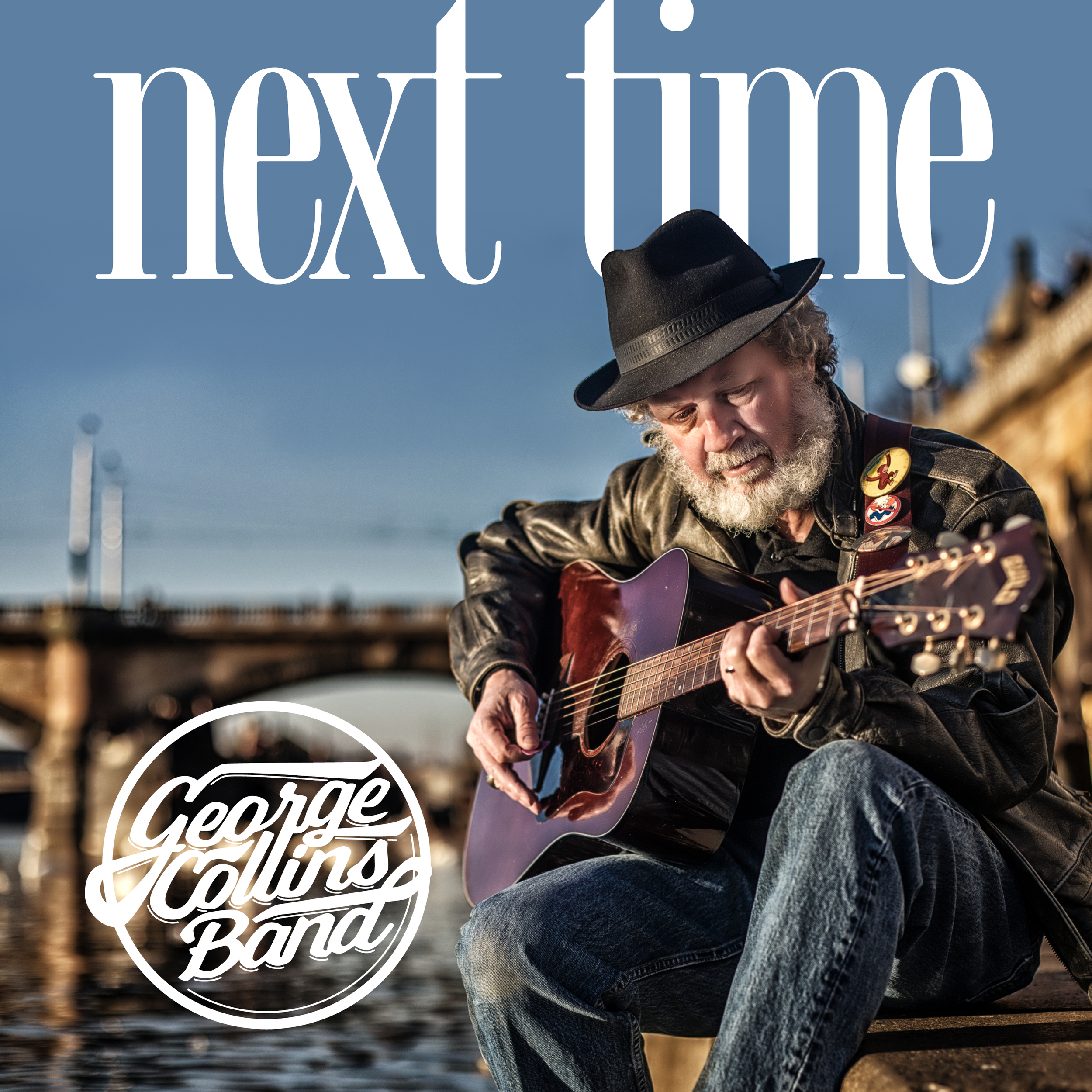 A man wearing a black hat and leather jacket playing an acoustic guitar outdoors with a blurred natural background and a circular graphic overlay reading 'Gerry Feelin's Band'.