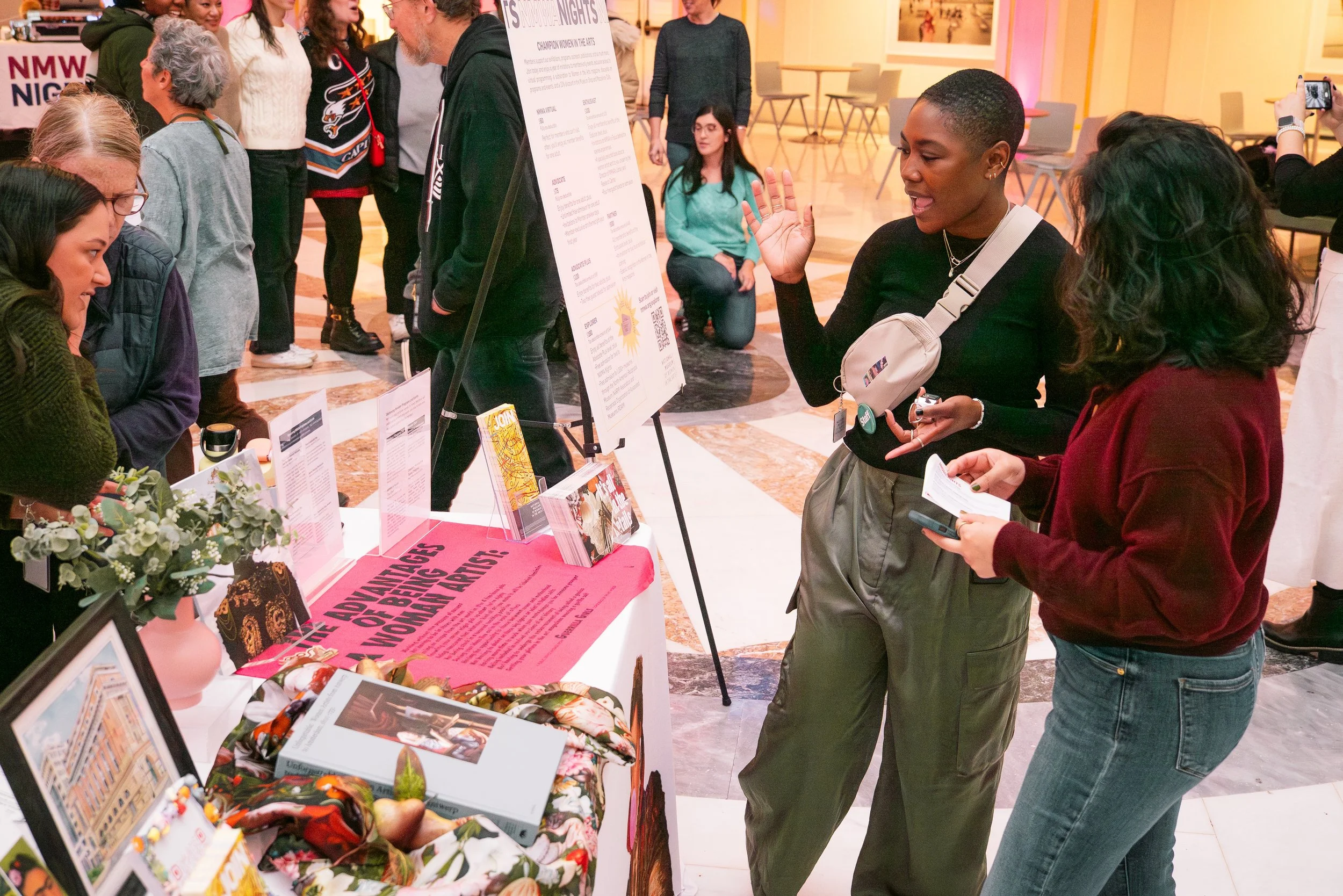 A staff member informs an attendee about membership options during the November 2025 NMWA Nights.