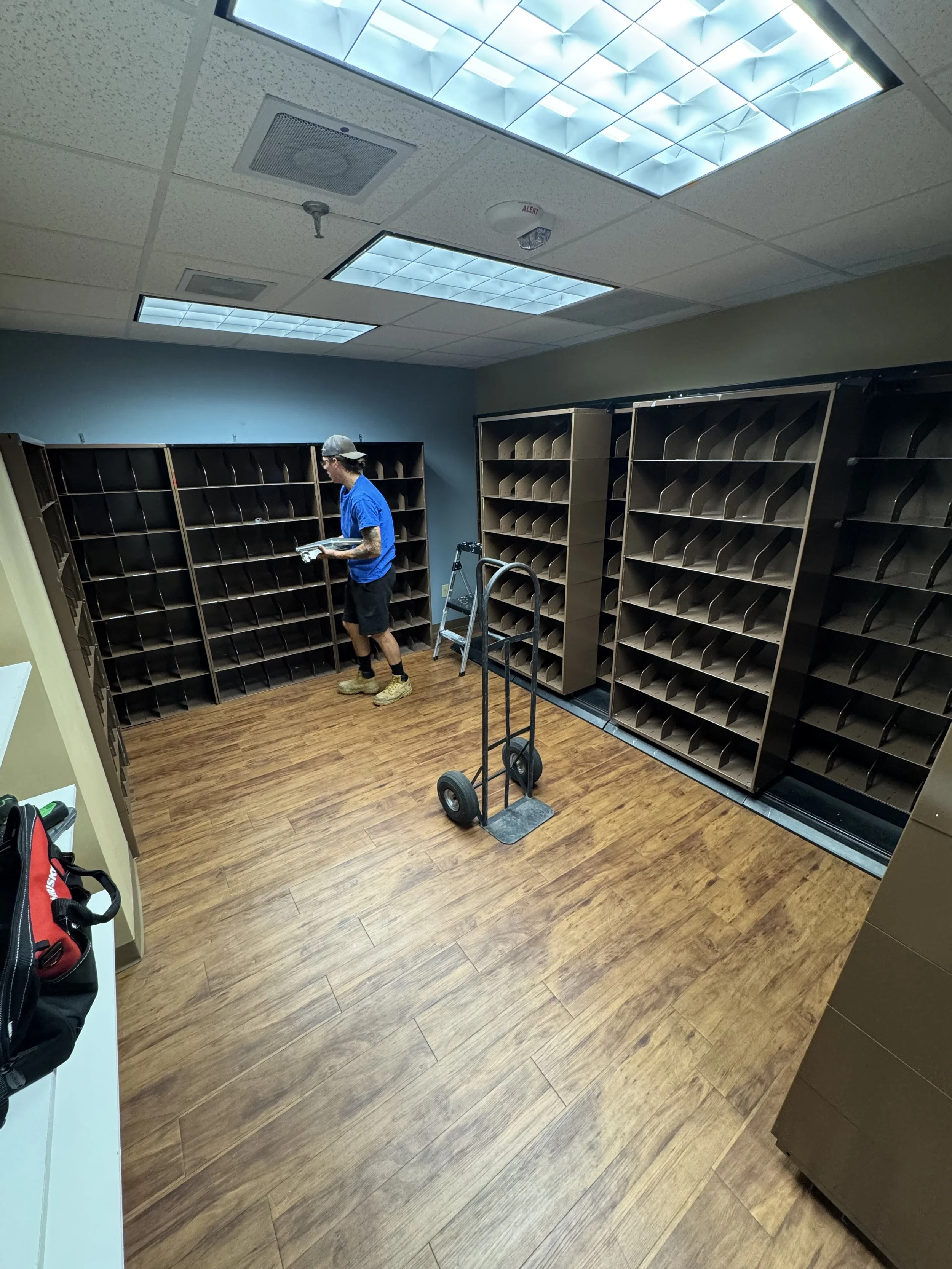 Business owner removing metal shelving from a hospital office room . Show casing that the offer commercial junk removal services